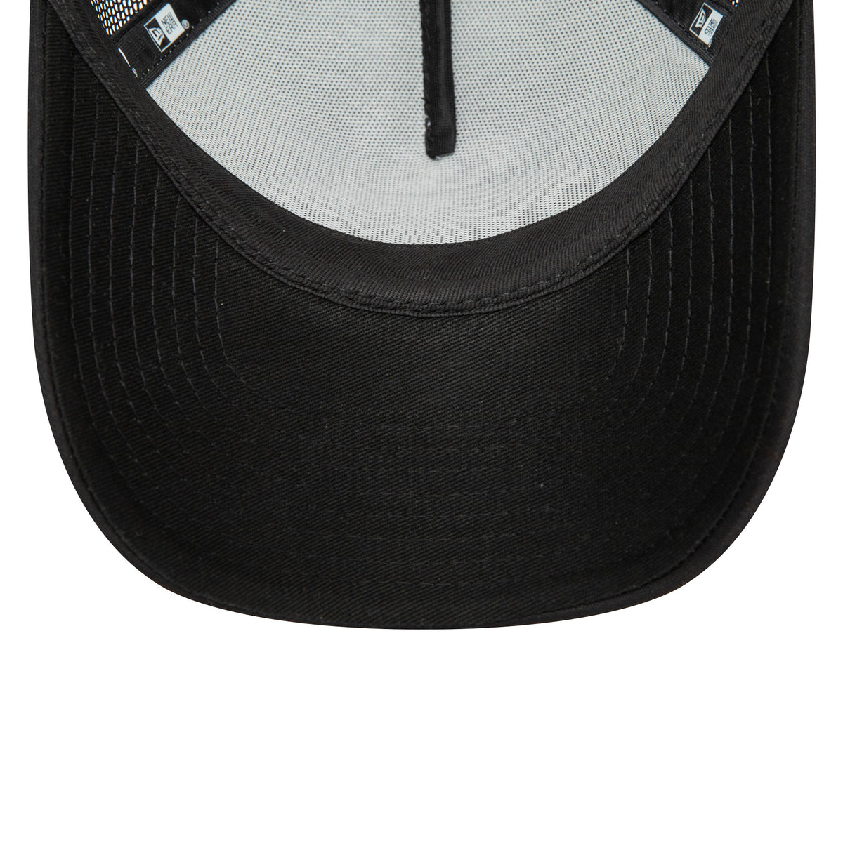 New Era Youth Black Oval Trucker Cap, inside view showing the black taping along the seams, a black sweatband, and a white mesh panel across the top back, with the New Era flag logo on the black undervisor.