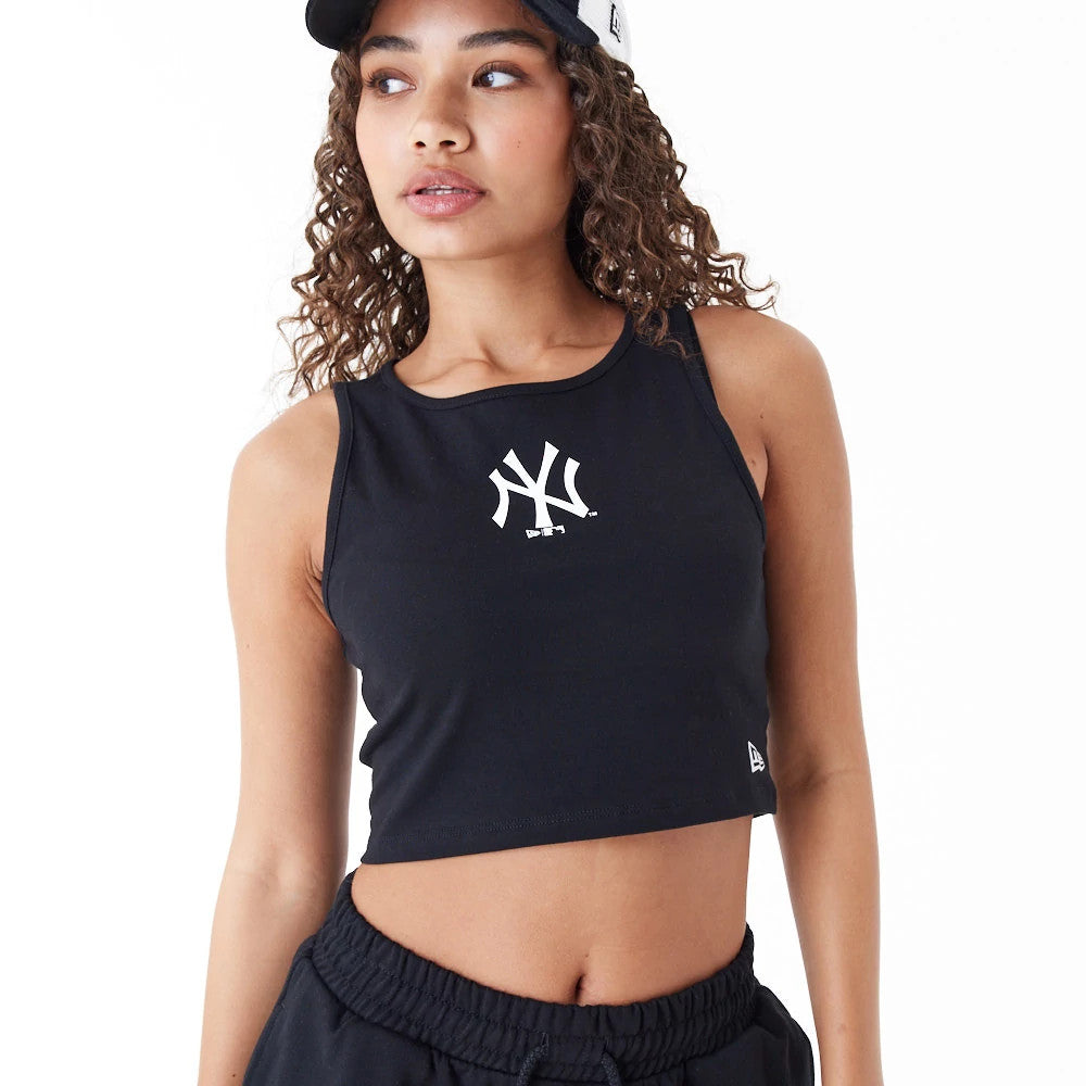 New York Yankees Womens MLB Lifestyle Black Crop Tank Top, front view on a model wearing a white cap, featuring a white Yankees logo centred on the chest and the New Era flag logo at the left hem.
