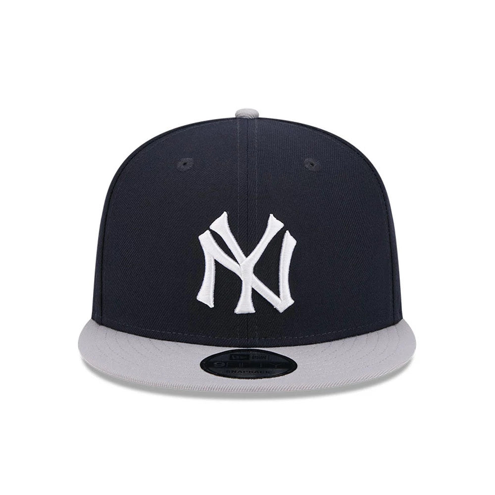 New York Yankees MLB Evergreen Navy New Era 9FIFTY Snapback Adjustable Cap, front view showing raised white embroidered NY logo on structured navy crown with a grey visor and 9FIFTY size sticker on top.