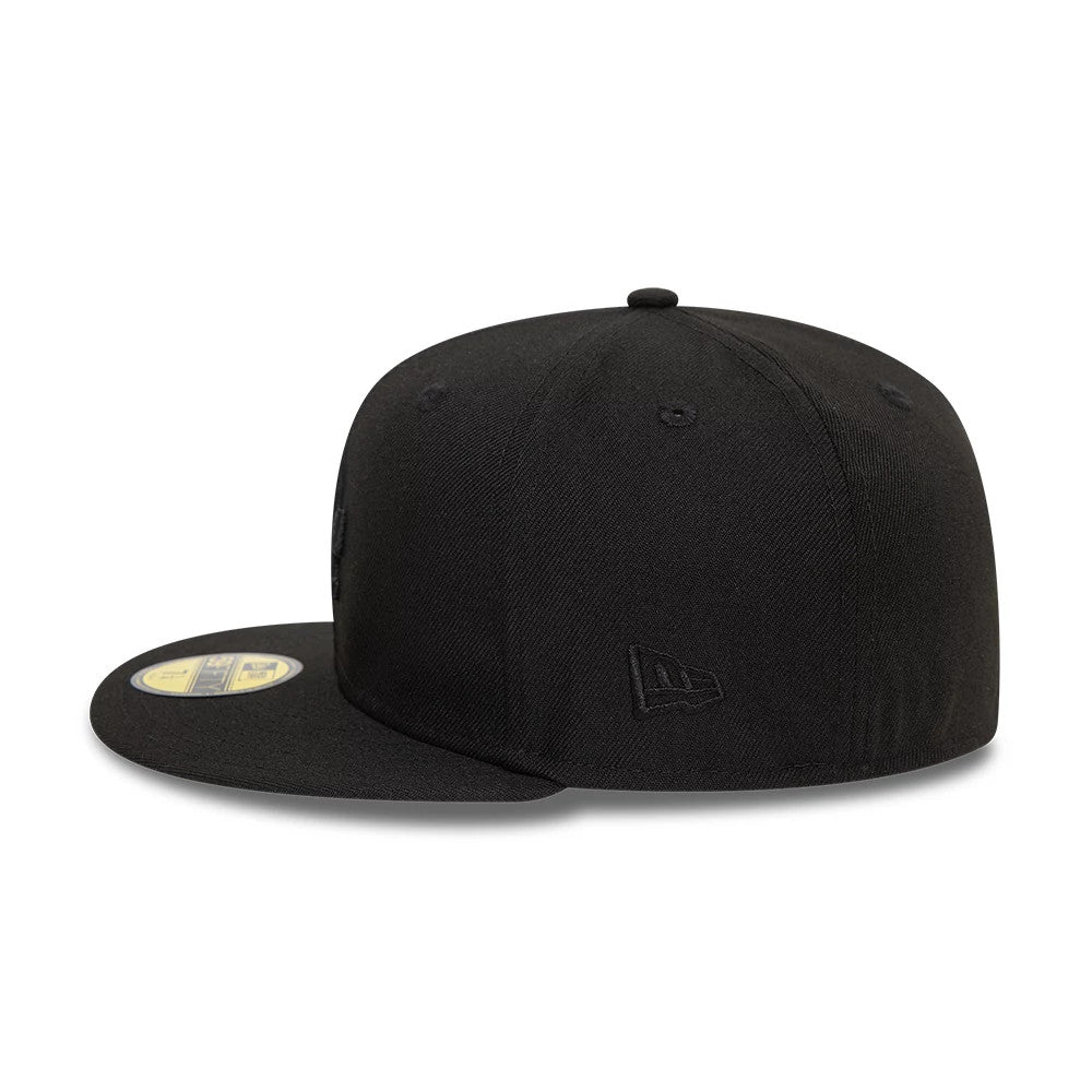 LA Dodgers League Essential Black New Era 59FIFTY Fitted Cap, side view showing the black New Era flag logo on the left side of the structured black crown with a flat visor and gold 59FIFTY size sticker.