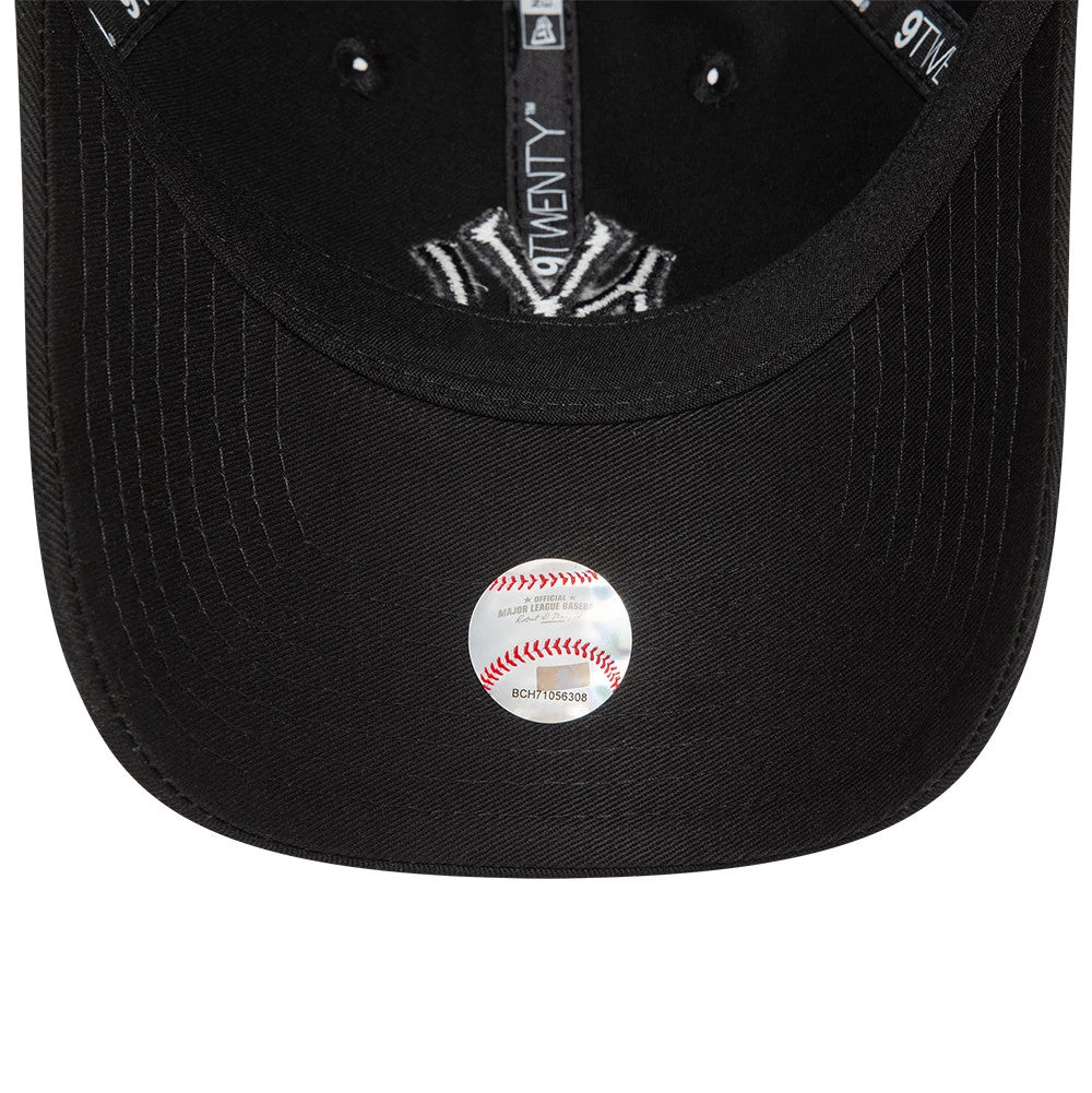 New York Yankees League Essential Black On Black New Era 9TWENTY Adjustable Cap, inside view showing black taping with 9TWENTY branding, a black sweatband, and a transparent sticker on the underside of the visor.