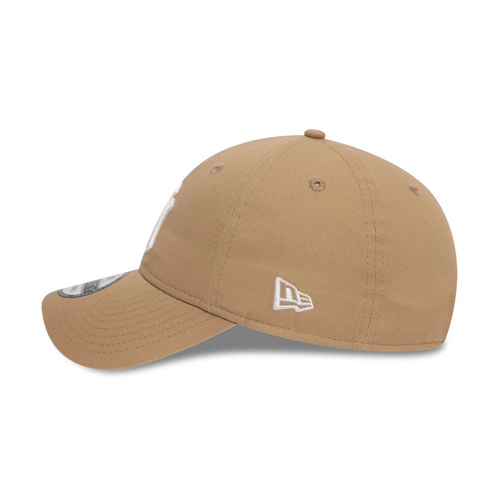 New York Yankees League Essential Light Beige New Era 9TWENTY Adjustable Cap, side view showing the white embroidered New Era flag logo on the left side, with a curved visor and 9TWENTY size sticker on top.