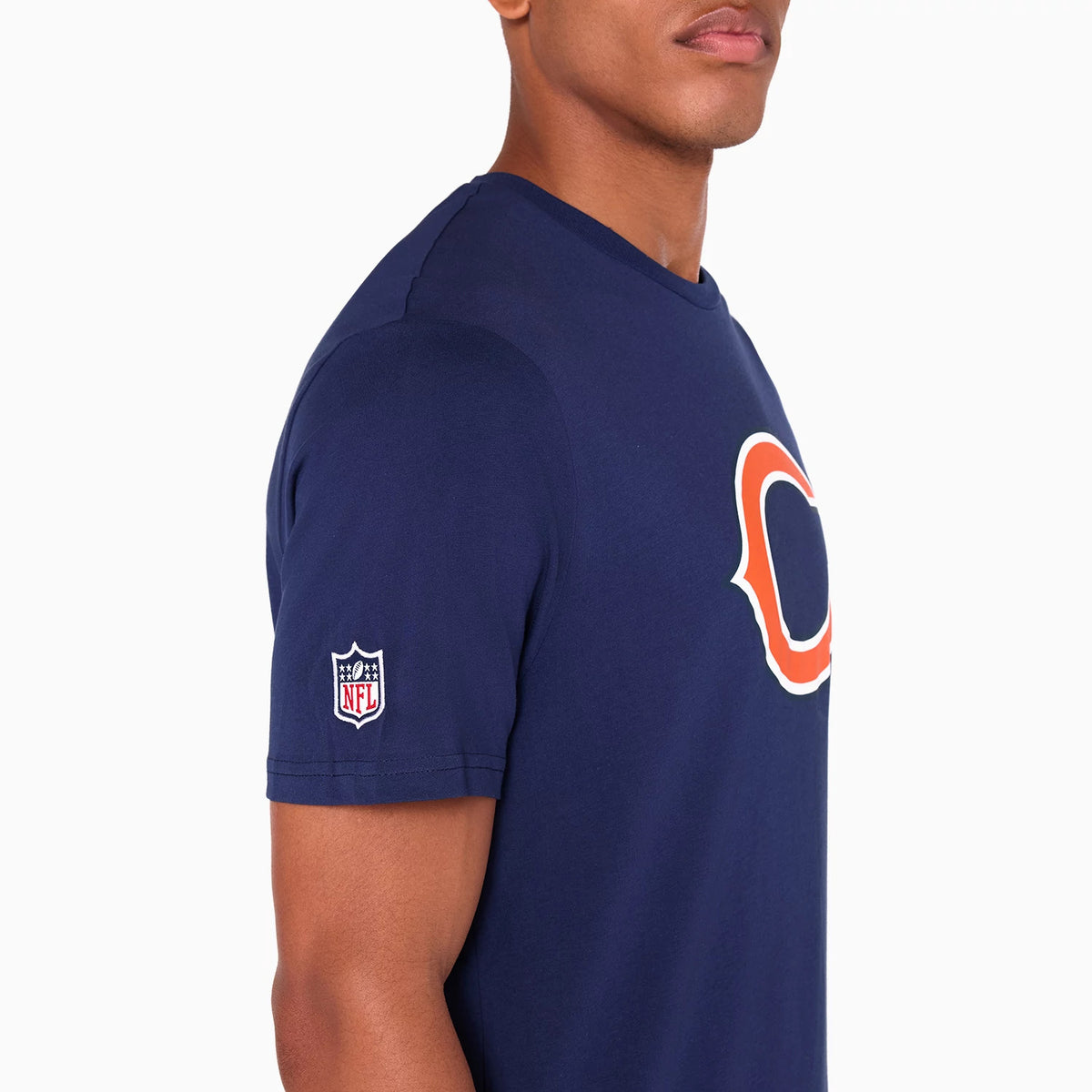 New Era Chicago Bears NFL Navy T-Shirt, side view showing an orange-outlined logo centred on the chest, a small embroidered NFL logo on the sleeve, and the navy fabric closely fitted to the model's torso.