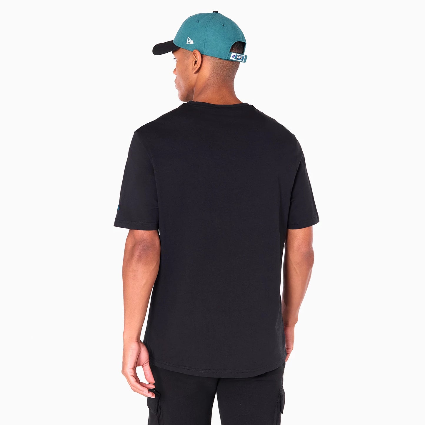 New Era Philadelphia Eagles NFL Black T-Shirt, on-model view showing the plain black back with short sleeves and an embroidered logo on a teal cap worn by the model, a black peak and eyelets on the cap.