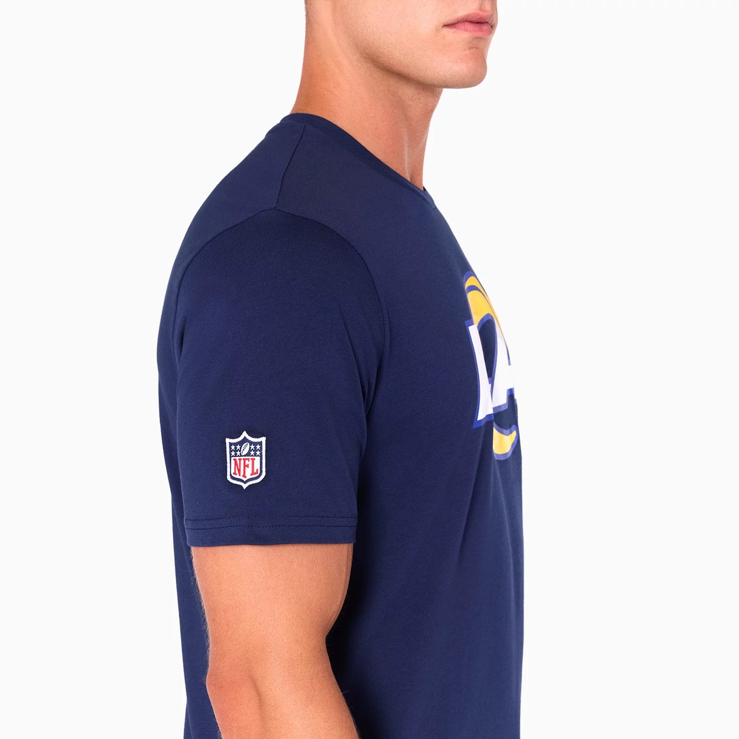 New Era LA Rams NFL Navy T-Shirt, side view showing the short sleeves with an embroidered NFL logo on the left arm and part of the bold LA Rams logo on the chest against a navy blue background.