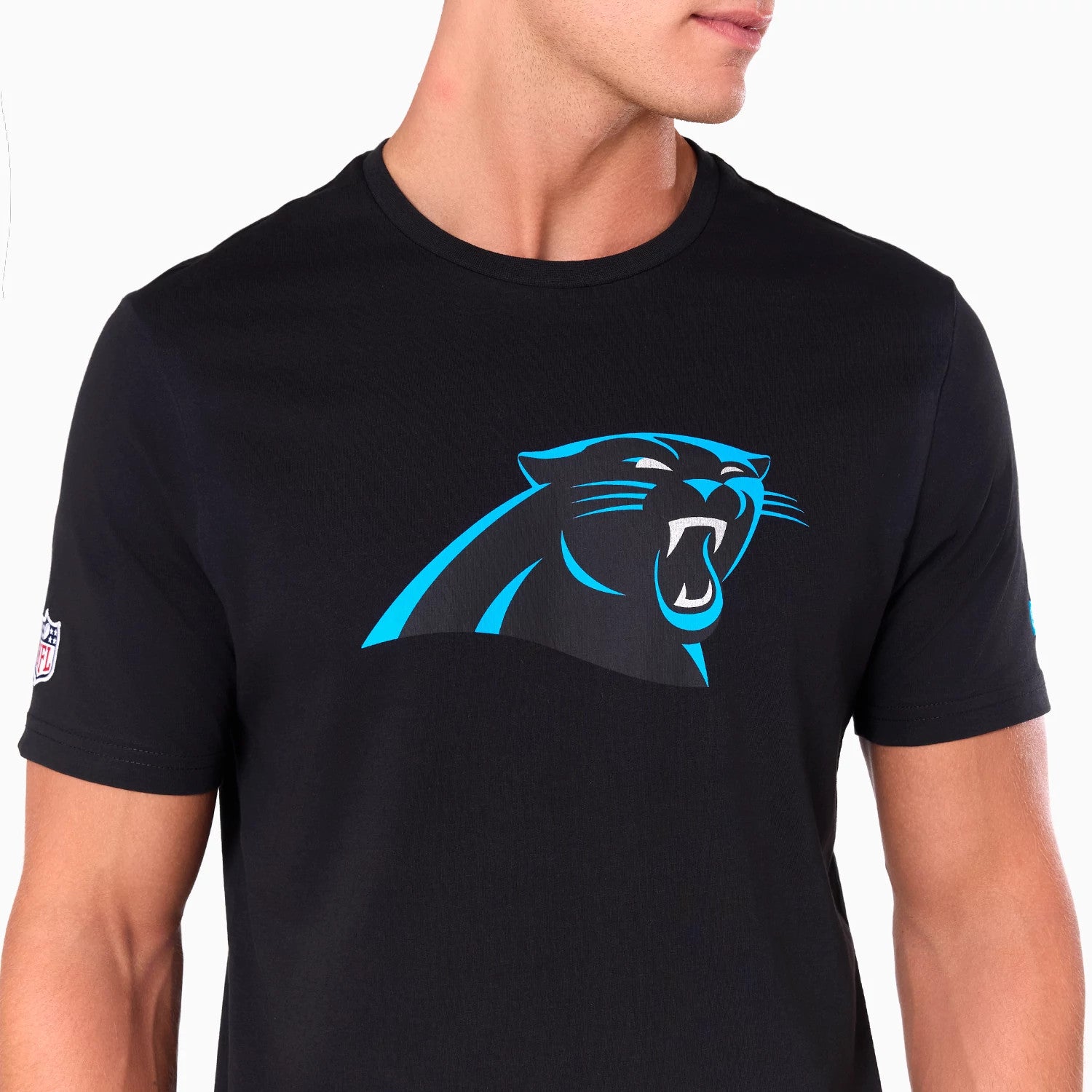 New Era Carolina Panthers NFL Black T-Shirt, front view showing the large blue and black panther logo printed on the chest and an embroidered NFL logo patch on the left sleeve against the plain black fabric.