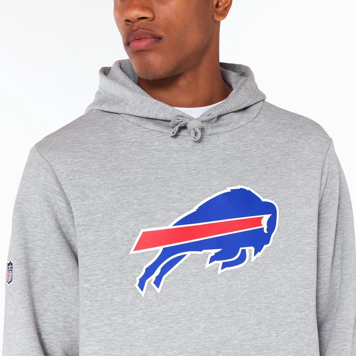 New Era Buffalo Bills NFL Grey Pullover Hoodie, front view showing a large blue and red Buffalo Bills logo centred on the chest, drawstrings at the neckline, and a small embroidered NFL patch on the left sleeve.