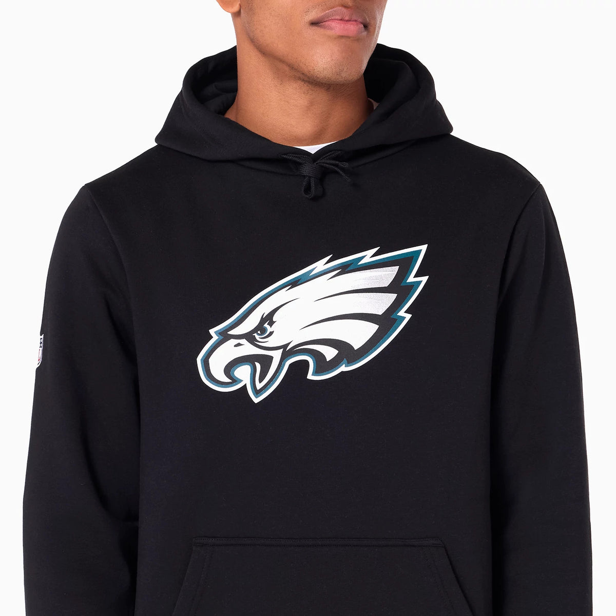 New Era Philadelphia Eagles NFL Black Pullover Hoodie, front view showing the large team logo in white and teal centred on the chest, a simple drawstring hood at the neckline, and a small logo on the left sleeve near the shoulder.