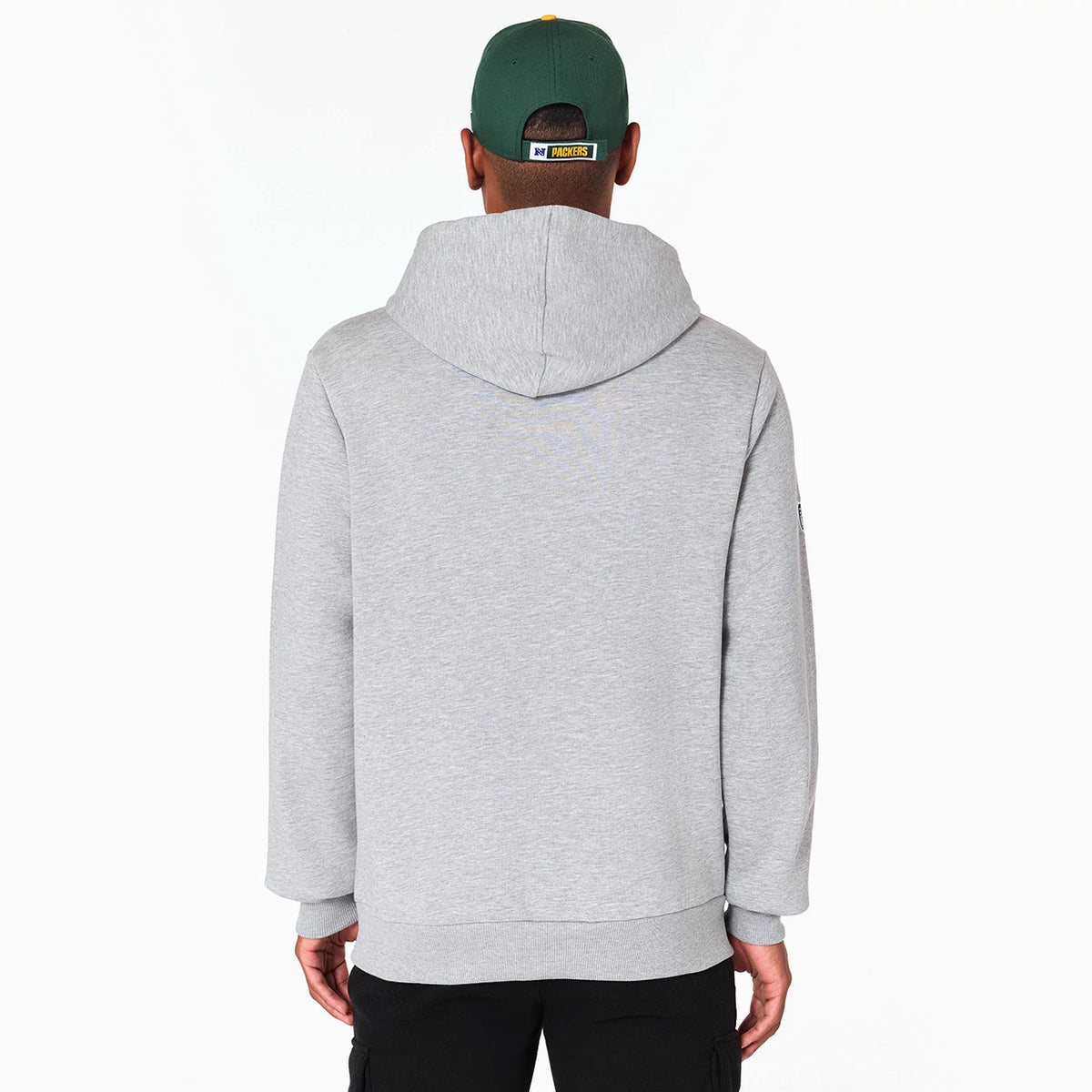 New Era Green Bay Packers NFL Grey Pullover Hoodie, rear view showing the plain grey back with an attached hood, worn by a model in a green cap with a raised Packers logo tag on the back of the cap.