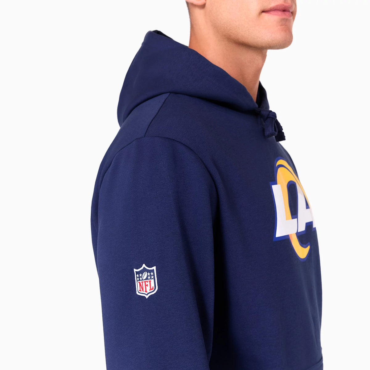 New Era LA Rams NFL Navy Pullover Hoodie, side view showing a navy hoodie with a large LA Rams logo on the chest and an embroidered NFL shield on the left sleeve, with a drawstring hood resting on the shoulders.