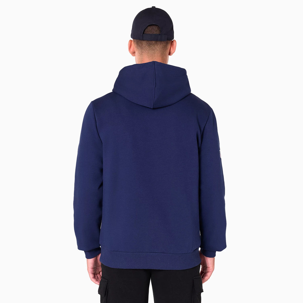 New Era LA Rams NFL Navy Pullover Hoodie, rear view showing the plain navy back with an attached hood, set against a plain design, being worn by a person in black trousers and a navy cap.