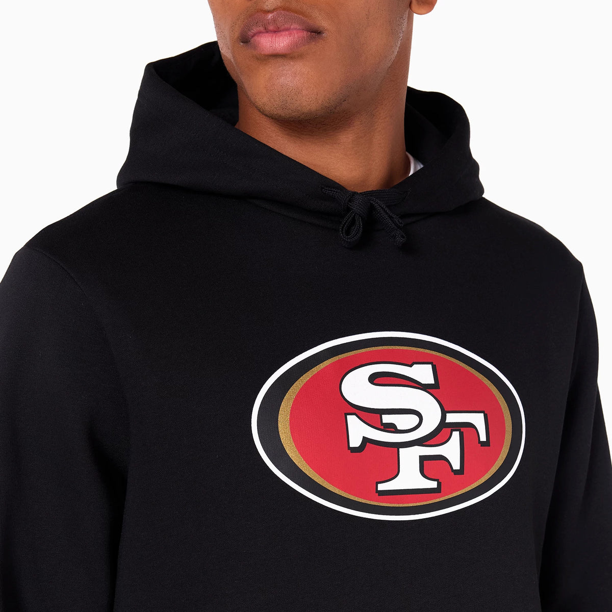 New Era San Francisco 49ers NFL Black Pullover Hoodie, front view showing a large raised team logo centred on the chest with red, white, and gold details, and a drawstring hood circling the neckline.
