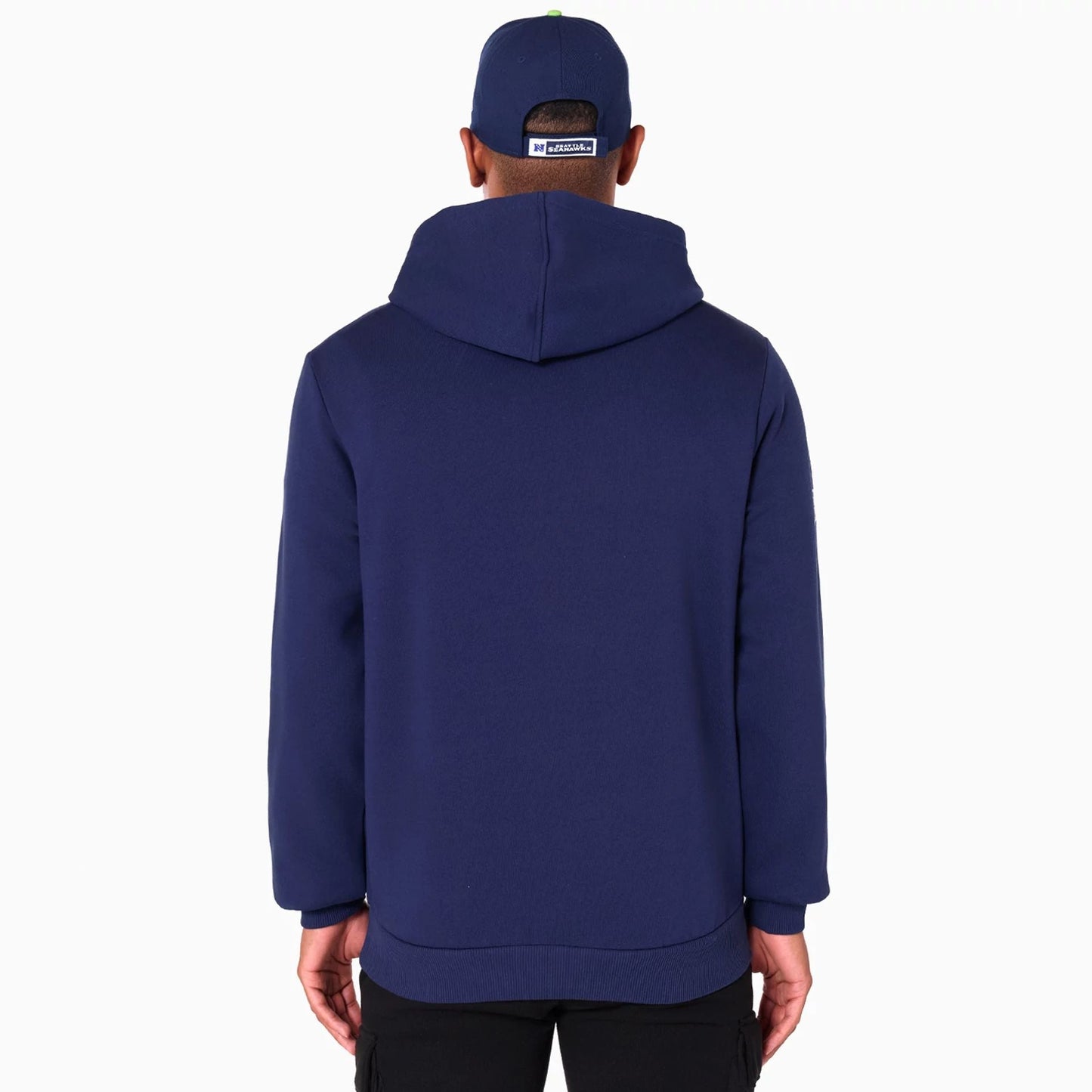 New Era Seattle Seahawks NFL Navy Pullover Hoodie, rear view showing a plain navy back with an attached hood, worn by a person also wearing a navy cap with a white raised New Era logo on the back.