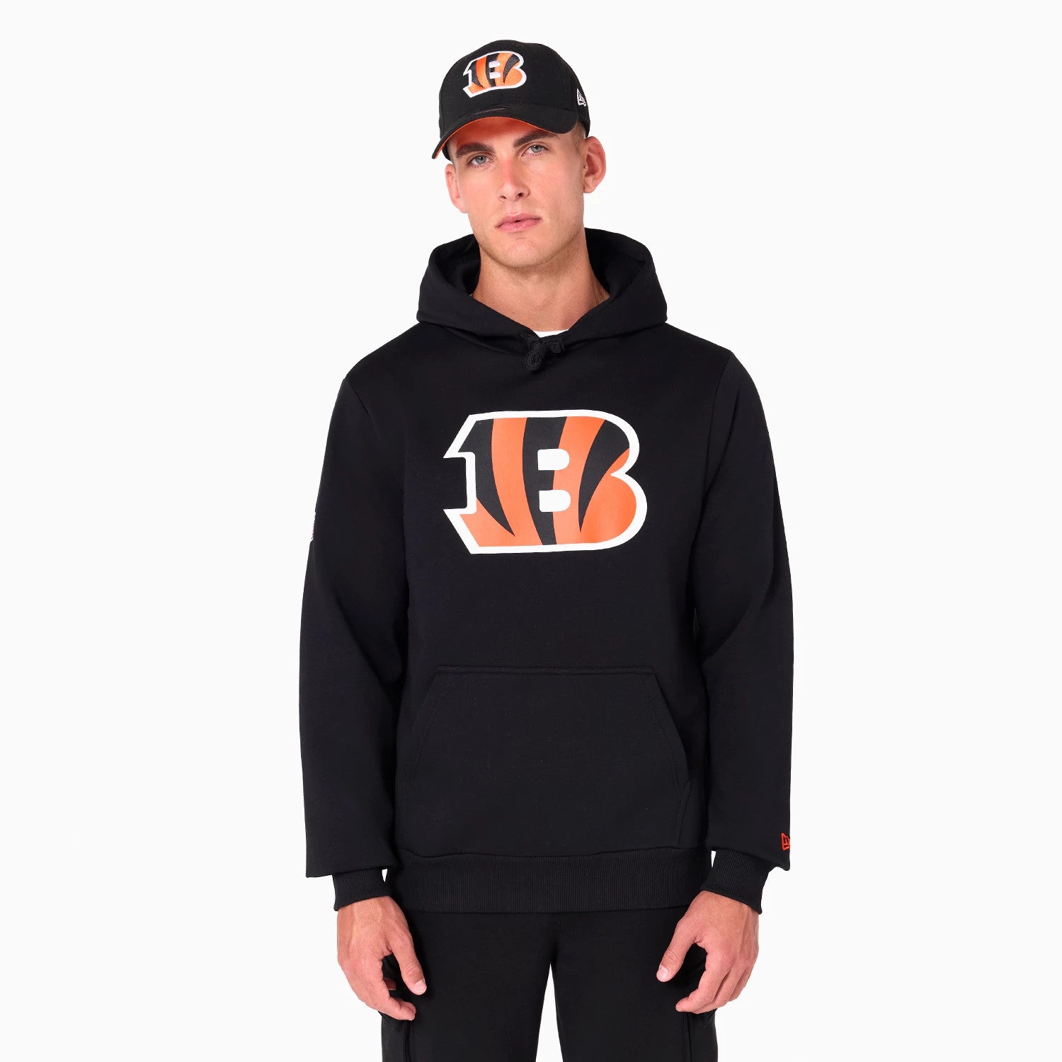 New Era Cincinnati Bengals NFL Black Pullover Hoodie, on-model view showing the black hoodie with a large orange and white Bengals logo centred on the chest, the model wearing a matching black cap with a raised team logo on the front.