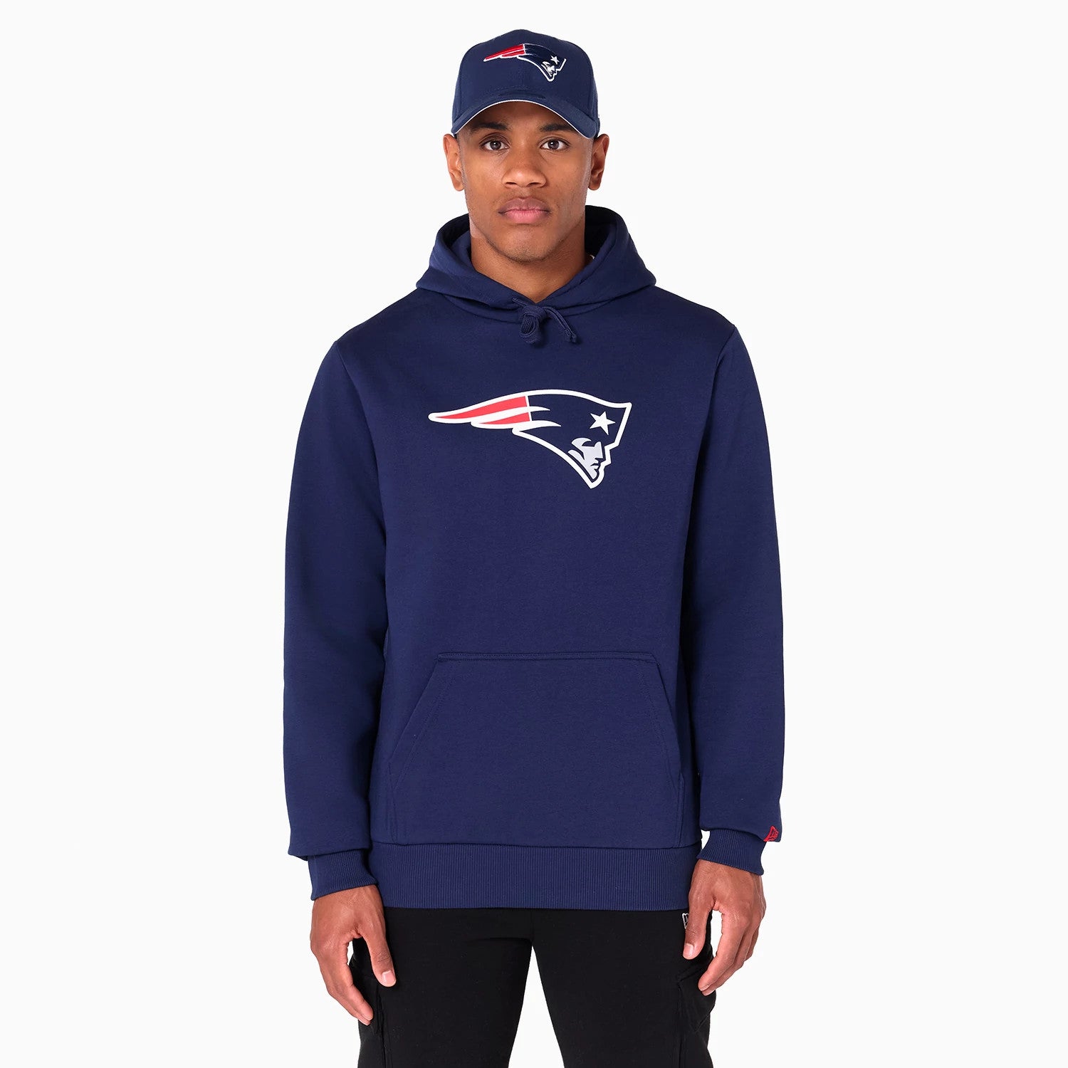 New Era New England Patriots NFL Navy Pullover Hoodie, on-model view showing the navy hoodie with a Patriots logo emblazoned on the chest, featuring a front pocket and matching navy cap with the same logo.