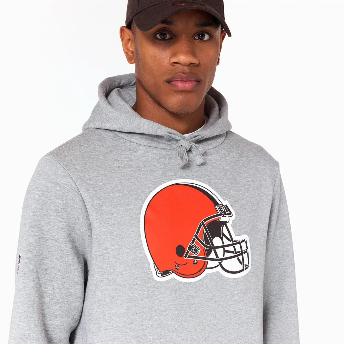 New Era Cleveland Browns NFL Grey Pullover Hoodie, on-model view showing the large Cleveland Browns helmet graphic in orange and white centred on the chest, the drawstring hood, and the small logo patch on the left sleeve.