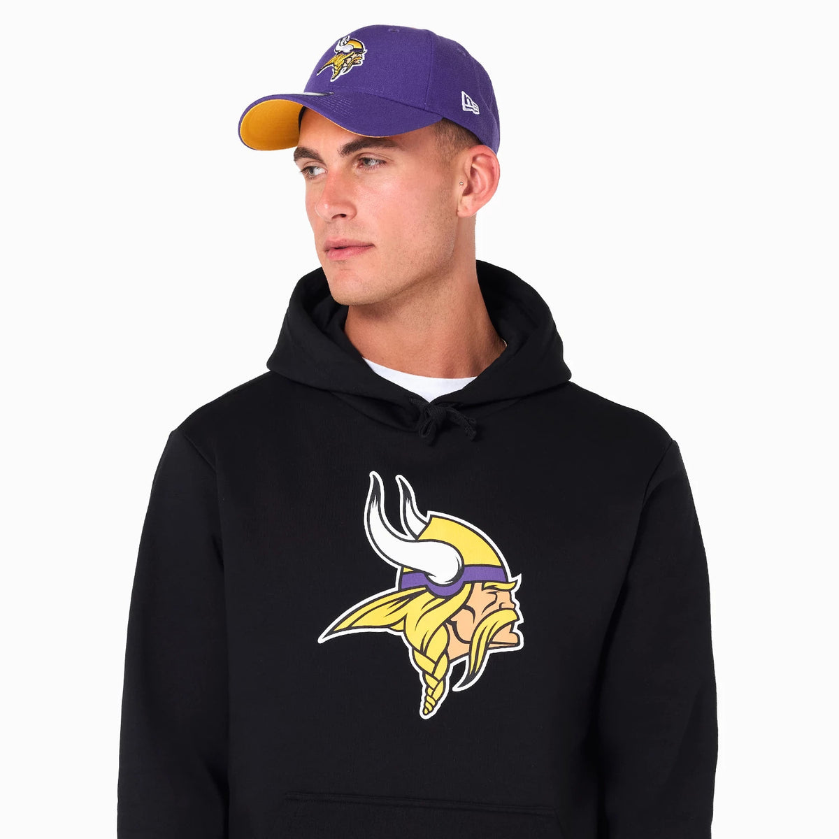 New Era Minnesota Vikings NFL Black Pullover Hoodie, on-model view showing a large Vikings logo printed on the centre of the chest, worn with a purple cap that features a raised Vikings logo on the front.