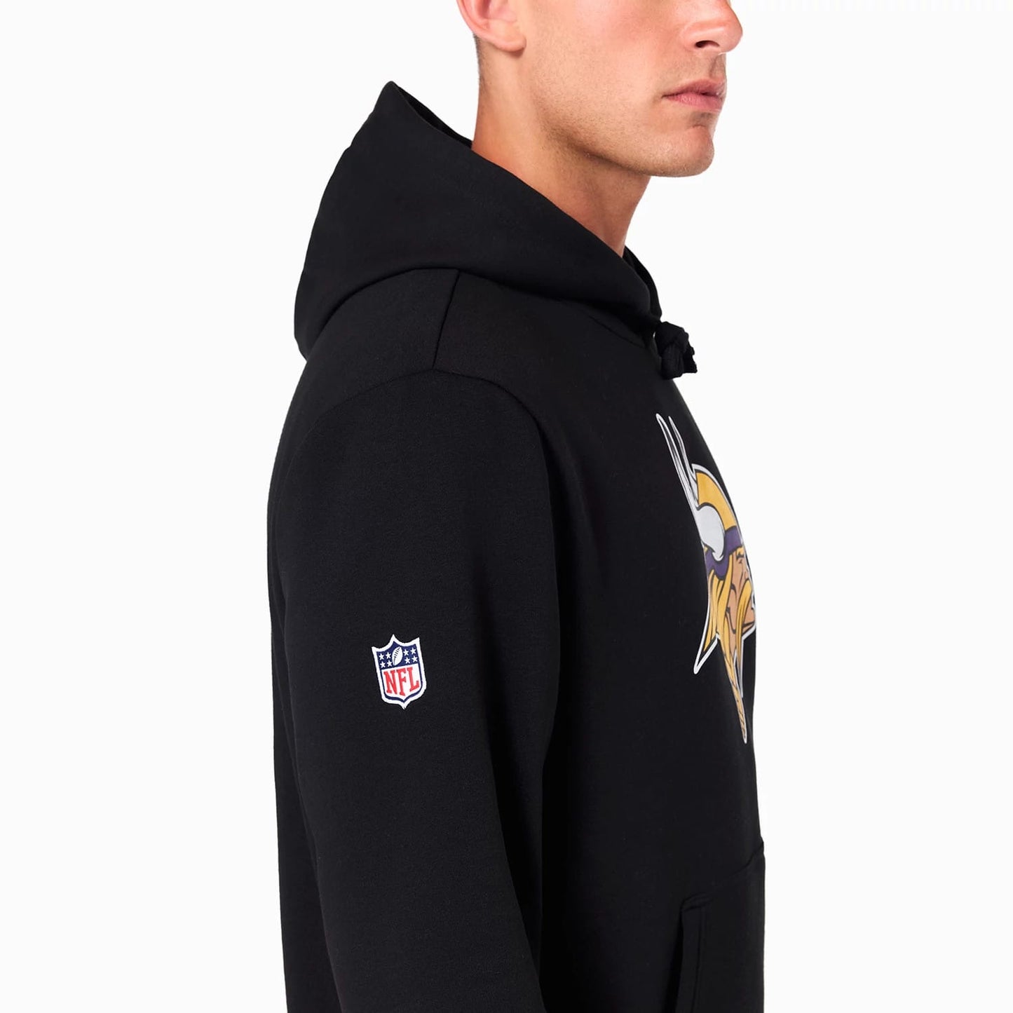 New Era Minnesota Vikings NFL Black Pullover Hoodie, side view showing the black fabric with a large Minnesota Vikings team logo printed on the chest, an embroidered NFL logo on the left sleeve, and a drawstring hood.