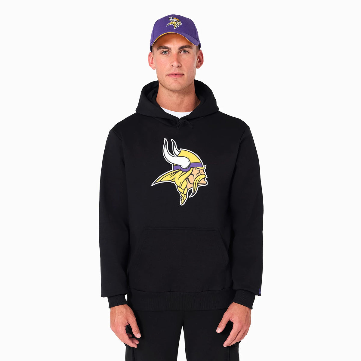 New Era Minnesota Vikings NFL Black Pullover Hoodie, front view showing the large yellow and white embossed team logo at the centre of the chest, worn by a model who is also wearing a purple cap with a similar logo.