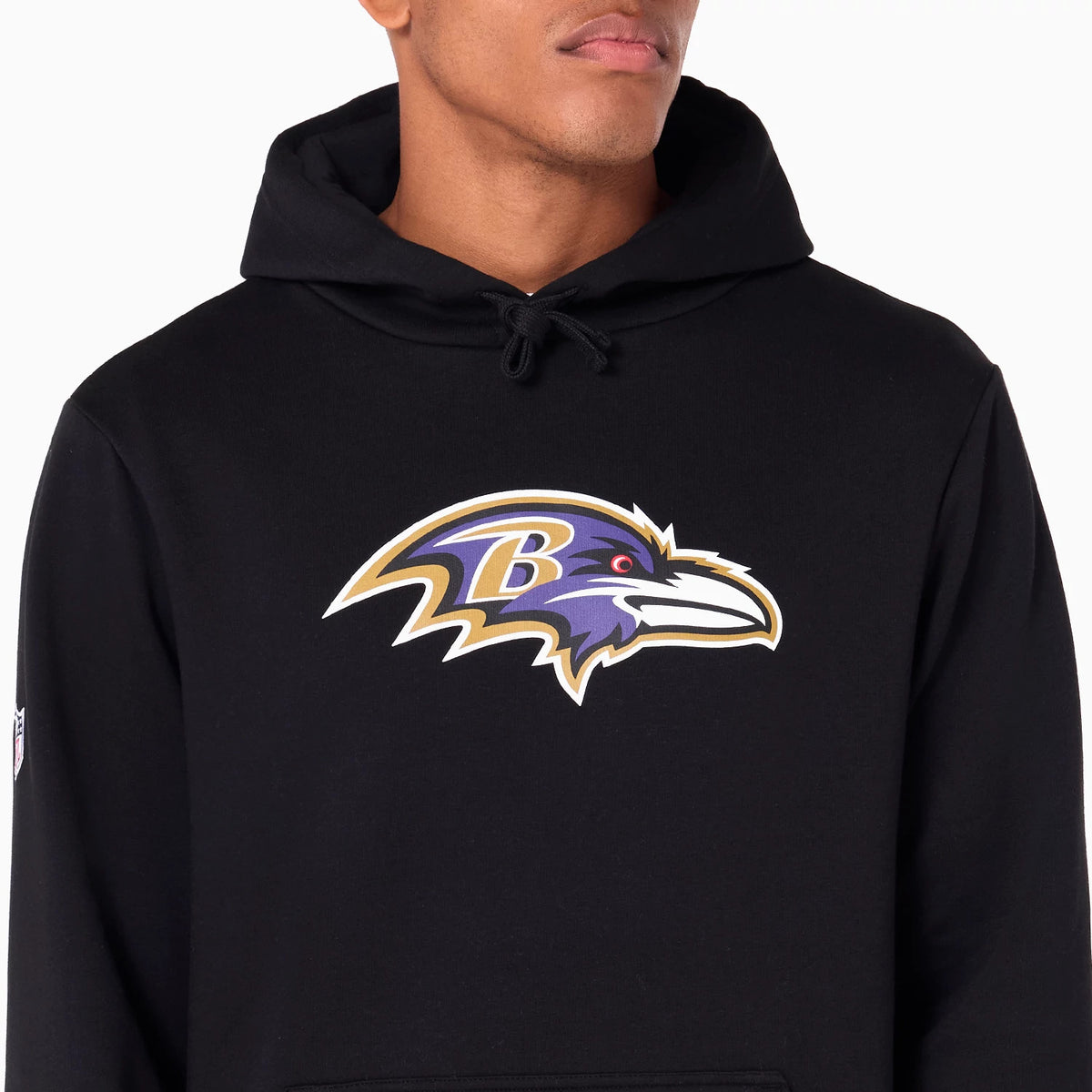 New Era Baltimore Ravens NFL Black Pullover Hoodie, front view showing the large centre-placed Baltimore Ravens logo on the chest, drawstring hood above, and a small NFL logo on the left sleeve.