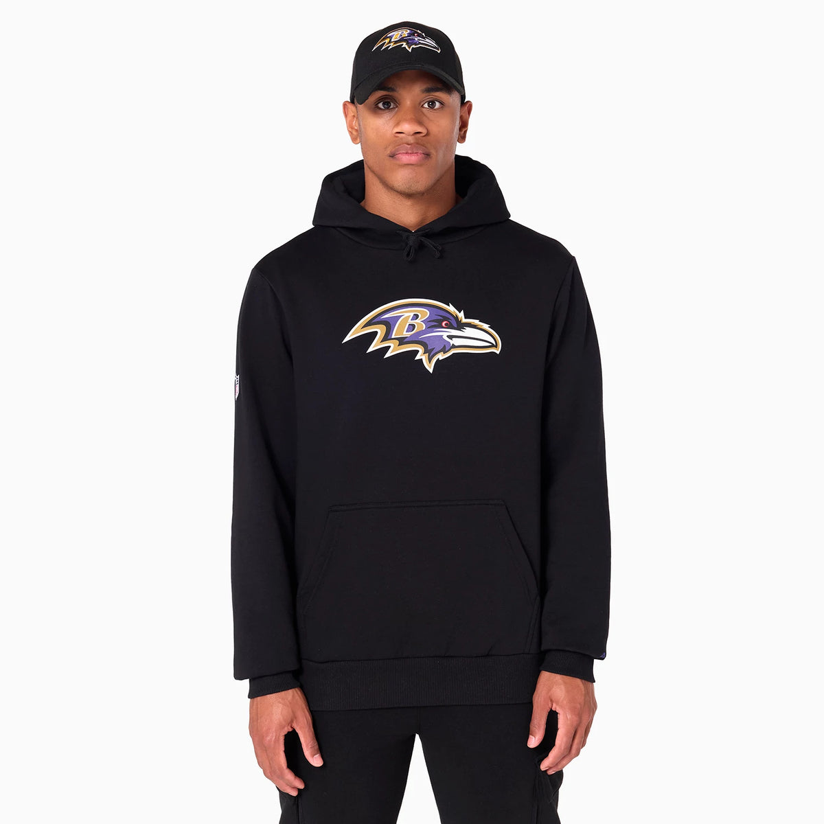 New Era Baltimore Ravens NFL Black Pullover Hoodie, on-model view showing the black hoodie with a large embroidered Baltimore Ravens logo centred on the chest, a drawstring hood and ribbed cuffs.