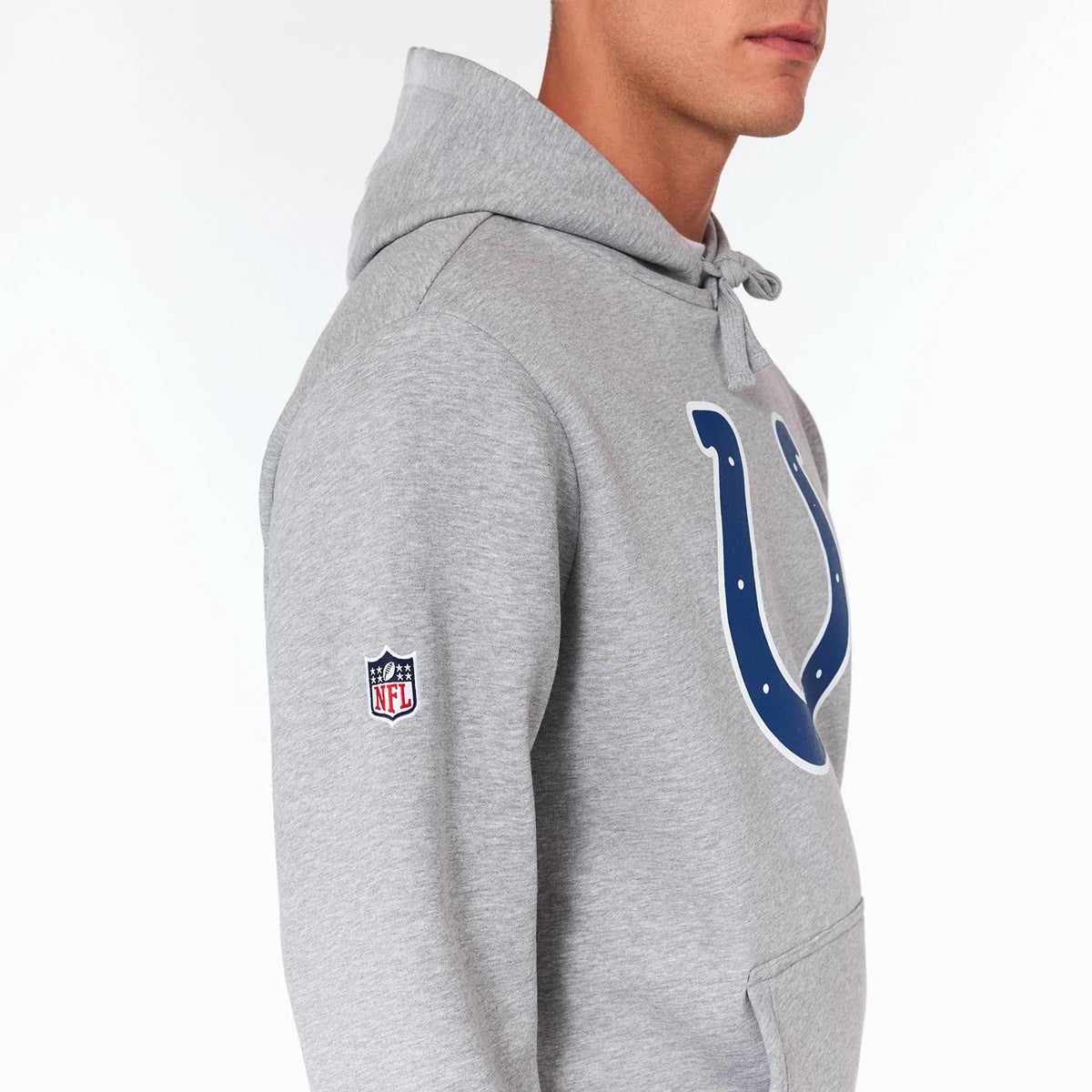 New Era Indianapolis Colts NFL Grey Pullover Hoodie, side view showing a raised blue horseshoe logo on the chest, a small embroidered NFL shield logo on the upper sleeve, and a front pocket pouch below the logo.