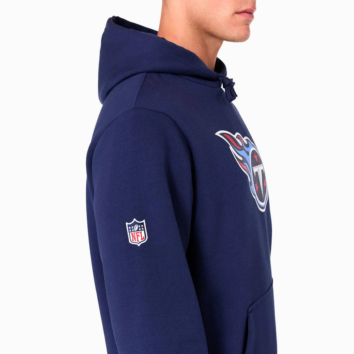 New Era Tennessee Titans NFL Navy Pullover Hoodie, side view showing the large Titans logo on the chest and the embroidered NFL logo on the upper sleeve of the navy hoodie worn by a model.