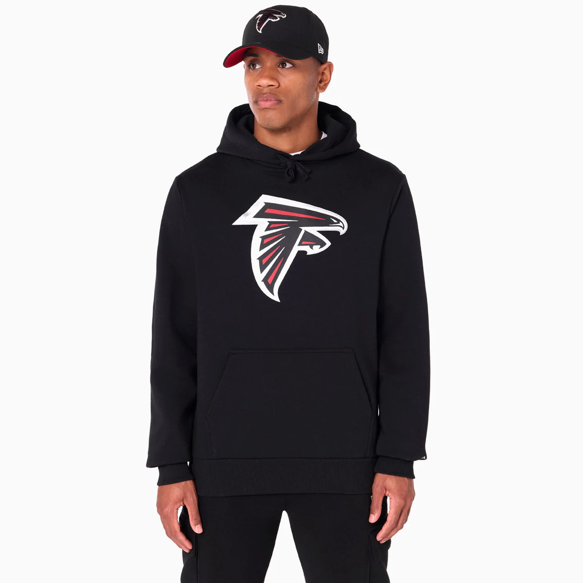 New Era Atlanta Falcons NFL Black Pullover Hoodie, front view showing a large printed Atlanta Falcons logo centred on the chest, with a black hood and drawstrings, worn by a model with a raised New Era logo on a black cap.