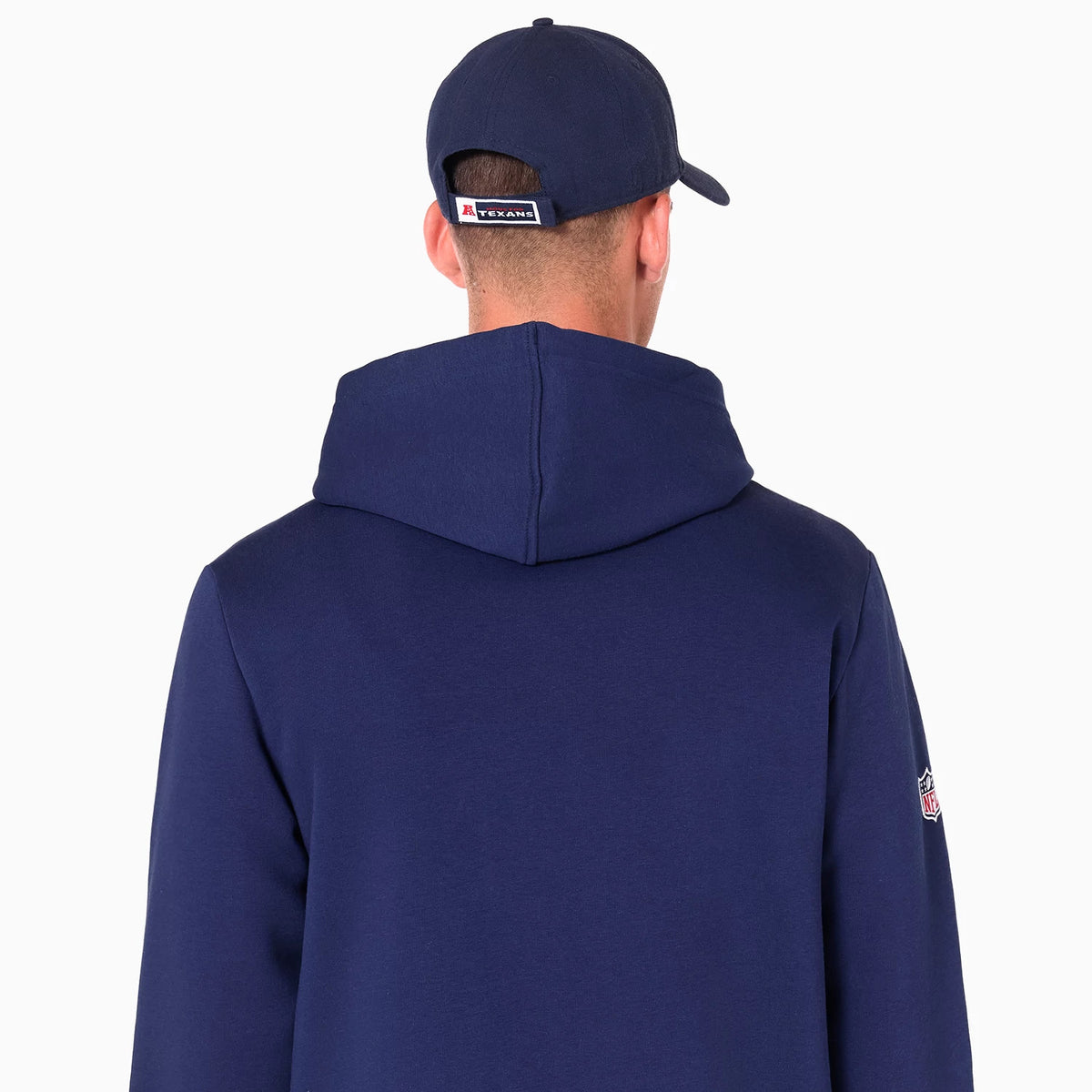 New Era Houston Texans NFL Navy Pullover Hoodie, rear view showing the hood draped over the back and sleeve with a small embroidered NFL logo, under a navy cap with an embossed logo above the adjustable strap.