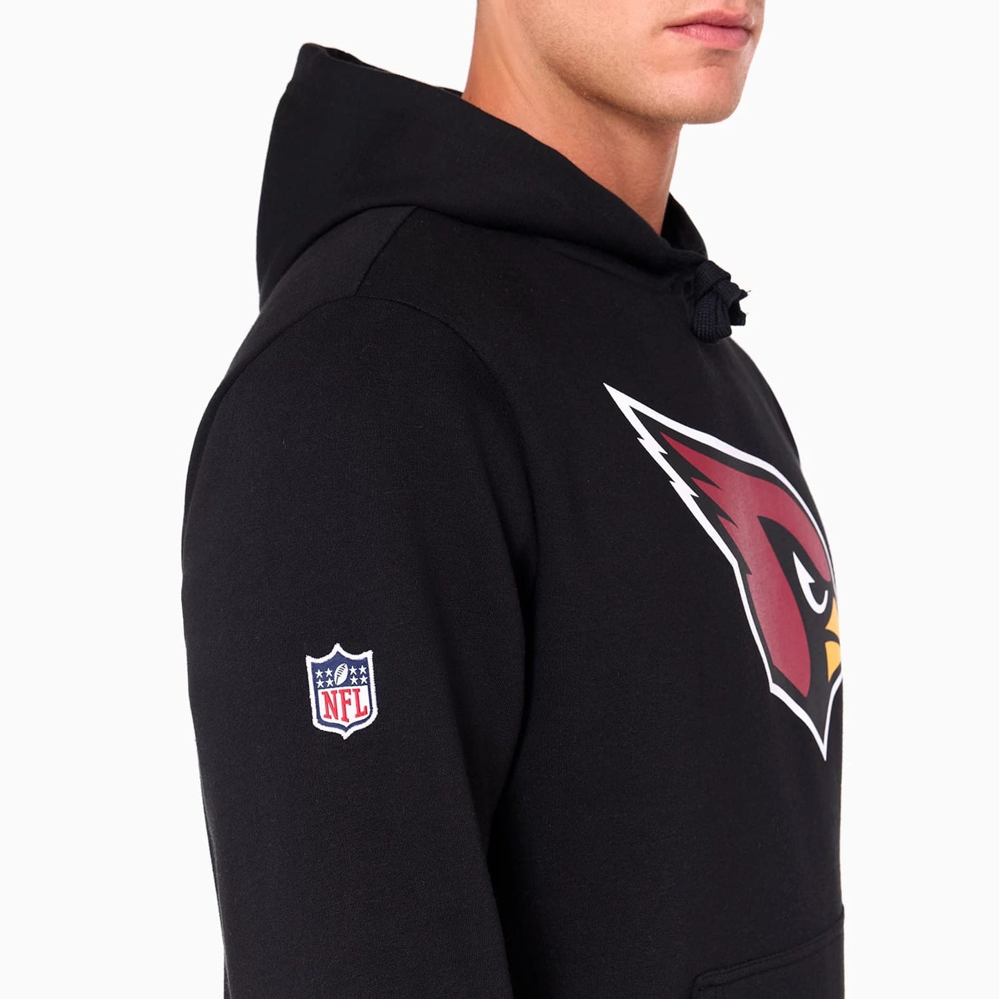 New Era Arizona Cardinals NFL Black Pullover Hoodie, side view showing the large red Cardinals logo printed on the chest and the embroidered NFL shield logo on the left sleeve, with a drawstring hood in black.