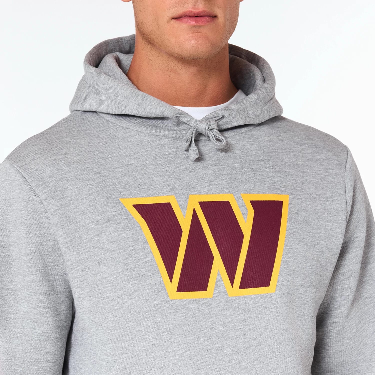 New Era Washington Commanders NFL Grey Pullover Hoodie, front view showing the light grey fabric with a large burgundy and gold W logo centred on the chest beneath the hood with adjustable drawstrings.