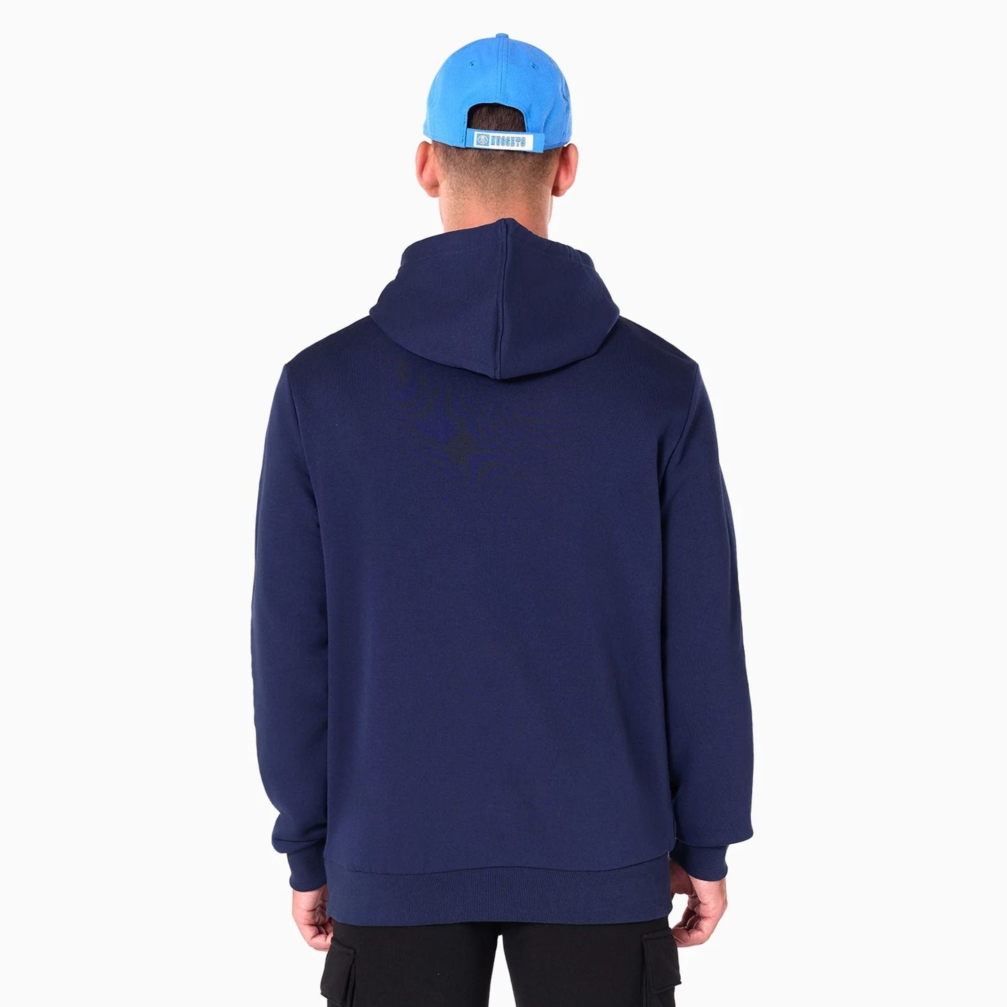 New Era Denver Nuggets NBA Navy Pullover Hoodie, rear view showing the navy fabric with a plain back and relaxed fit, worn by a person in a bright blue cap featuring a logo above the adjustable strap at the back.