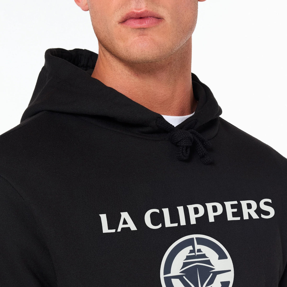 New Era LA Clippers NBA Black Pullover Hoodie, front view showing the black hood with drawstrings, white LA Clippers text across the chest, and a large team logo printed underneath on the fabric.