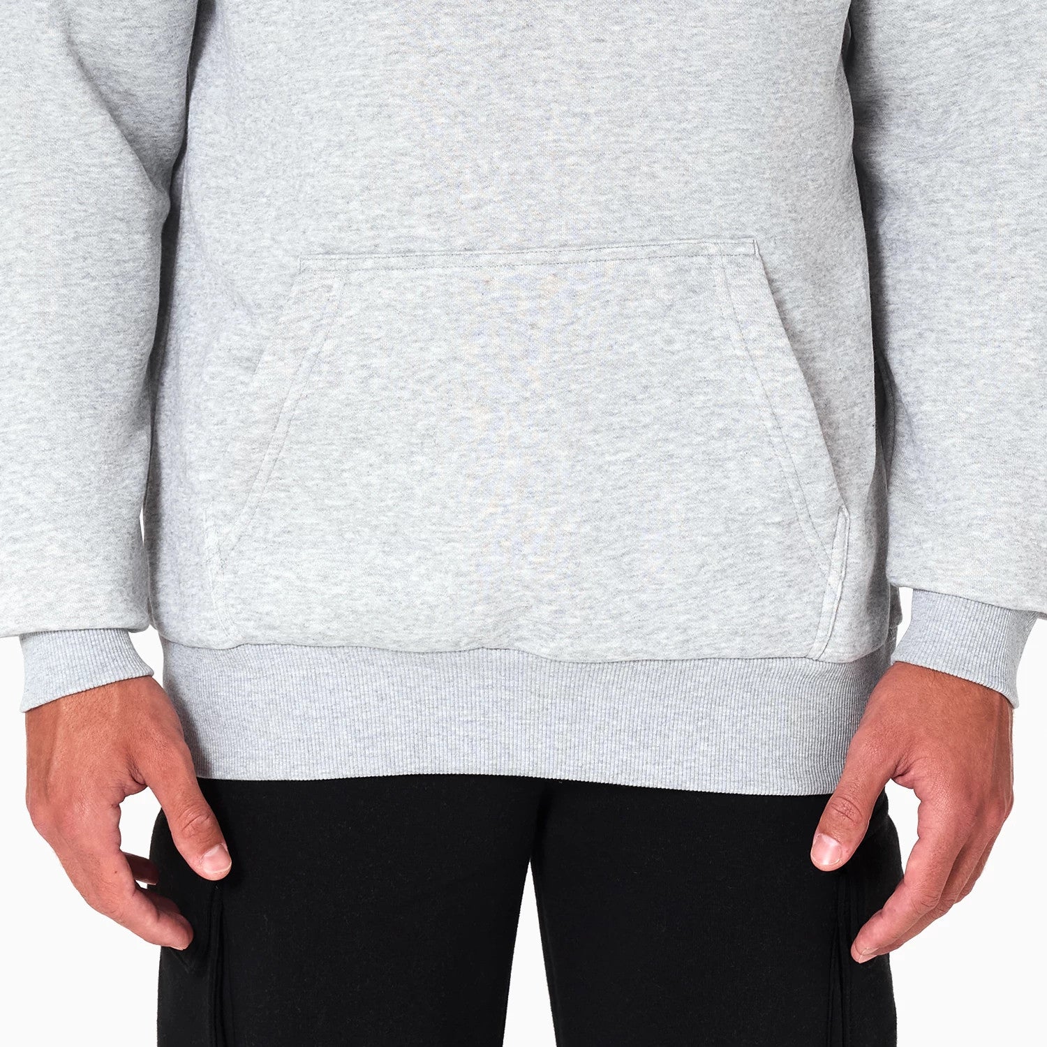 New Era Dallas Mavericks NBA Grey Pullover Hoodie, front view showing the lower half with a kangaroo pocket on the grey fabric, long sleeves with ribbed cuffs and hem, and a plain design.