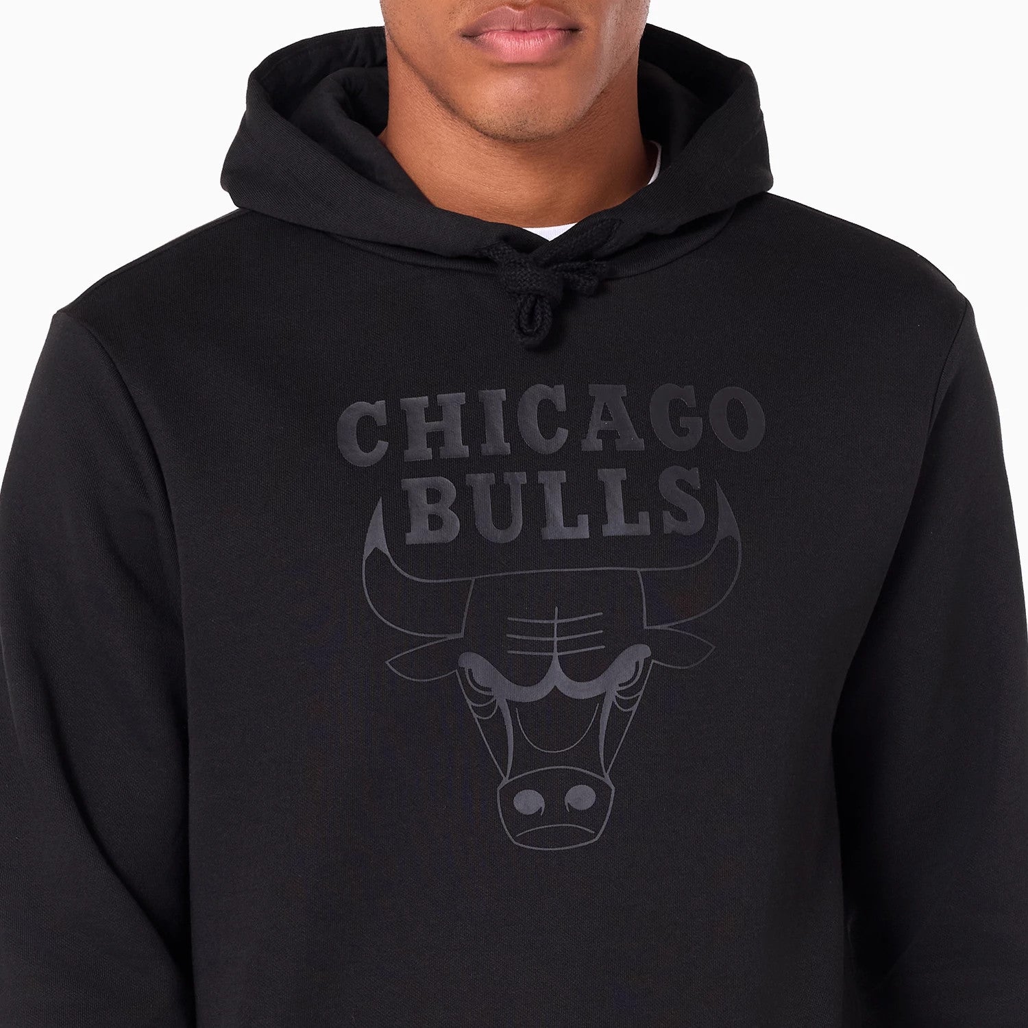 New Era Chicago Bulls NBA Black Pullover Hoodie, front view showing a large raised Chicago Bulls logo on the chest beneath the drawstring hood, with the text in bold letters and stylised bull head design.