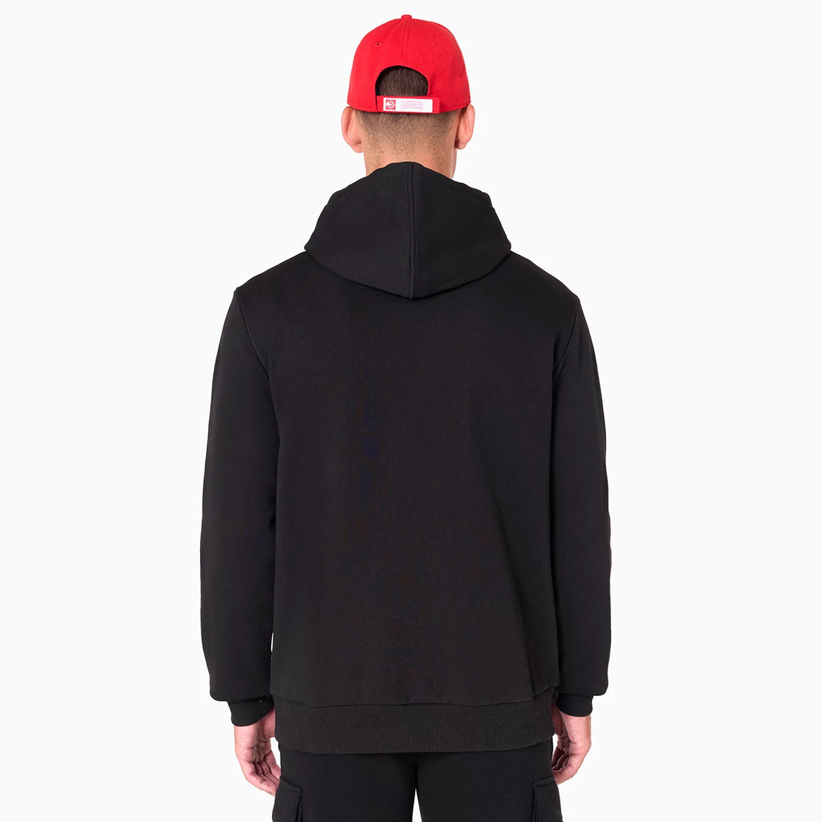 New Era Atlanta Hawks NBA Black Pullover Hoodie, rear view showing the plain black back with a hood resting against the shoulders, worn by a person in a red cap featuring a raised white logo at the back above the snap closure.