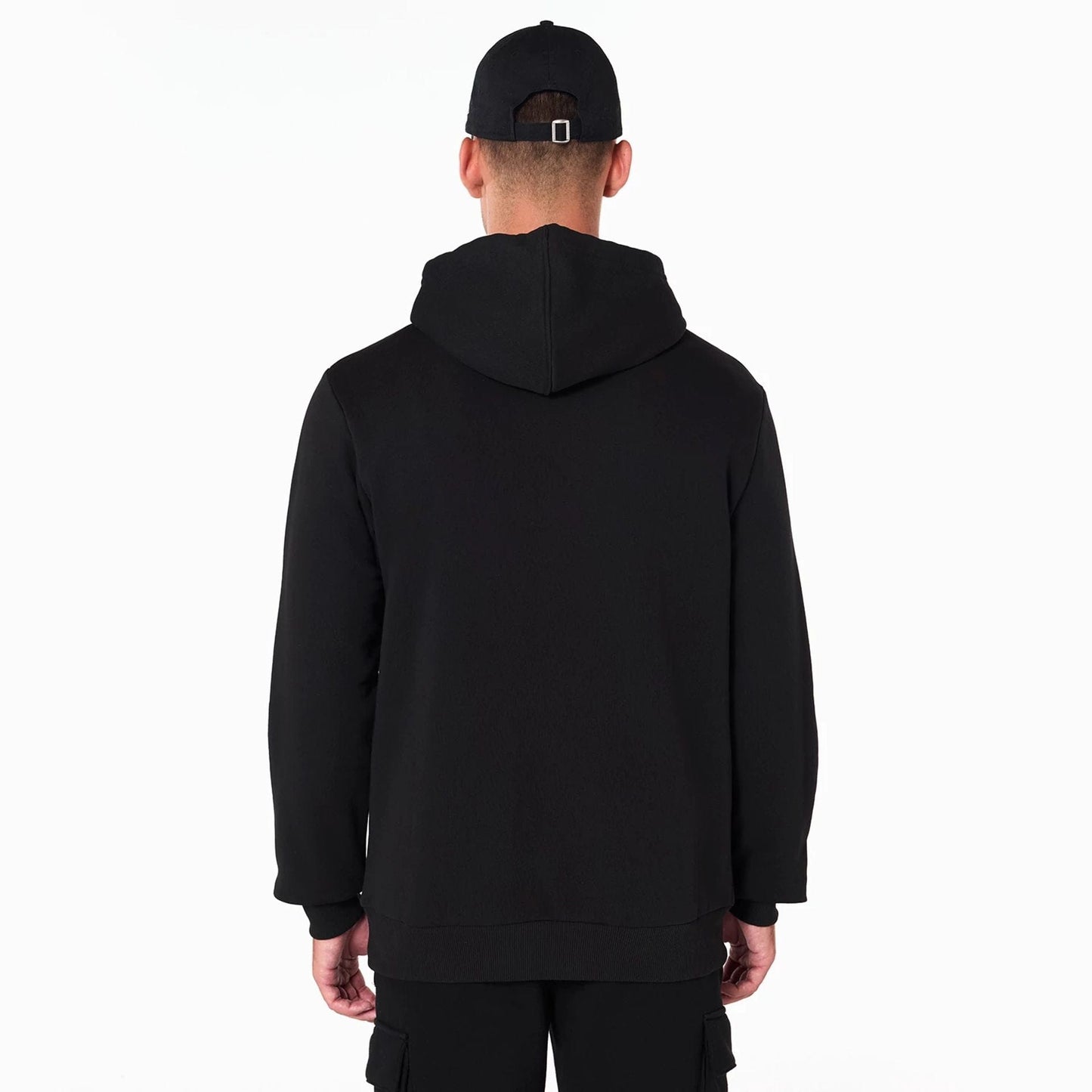 New Era Minnesota Timberwolves NBA Black Pullover Hoodie, rear view showing the plain black back with a hood resting flat, worn by a model also wearing a black cap with a debossed logo on it.