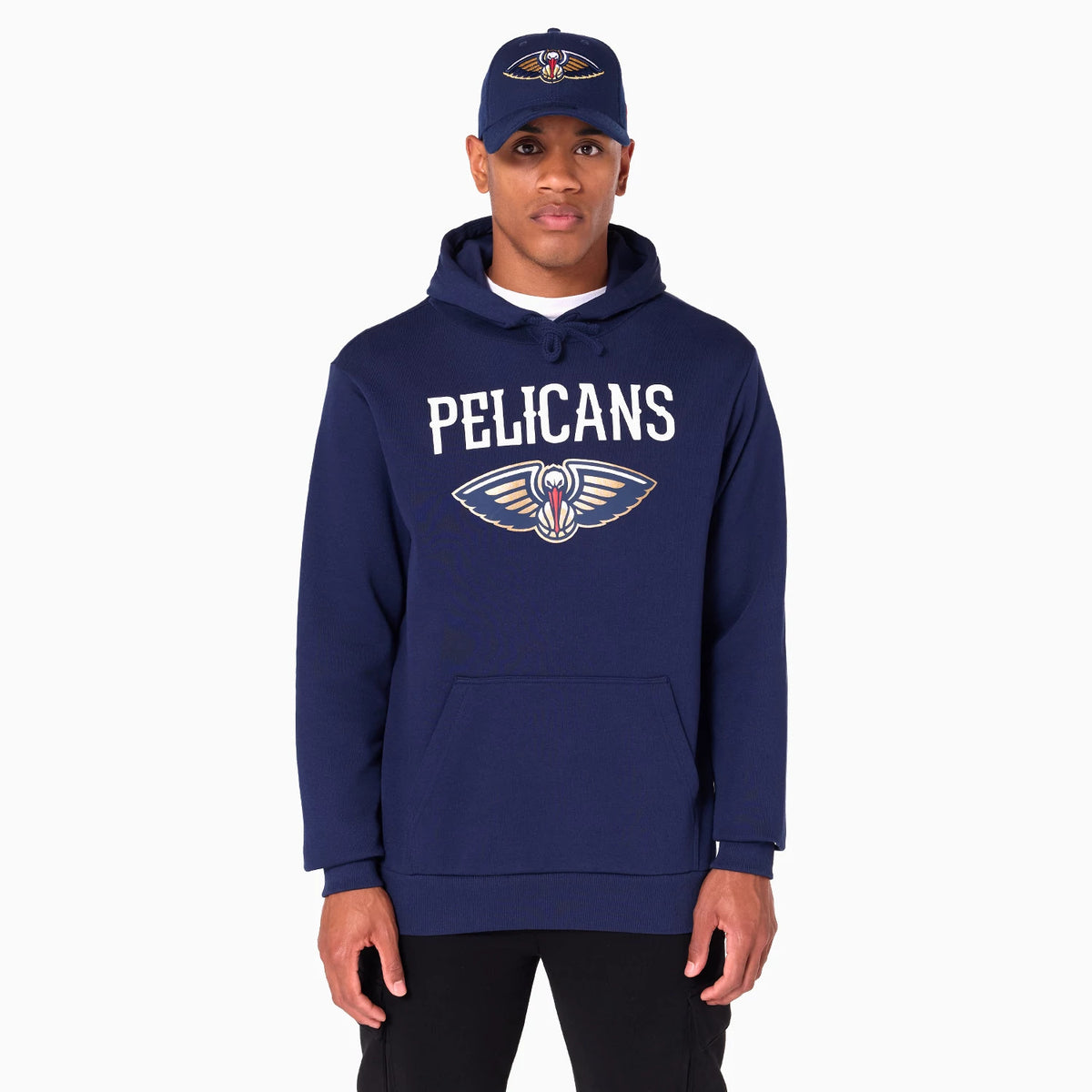 New Era New Orleans Pelicans NBA Navy Pullover Hoodie, on-model view showing the word PELICANS printed across the chest above the team logo on a navy background, with the hood up and worn with a matching cap featuring the same logo.