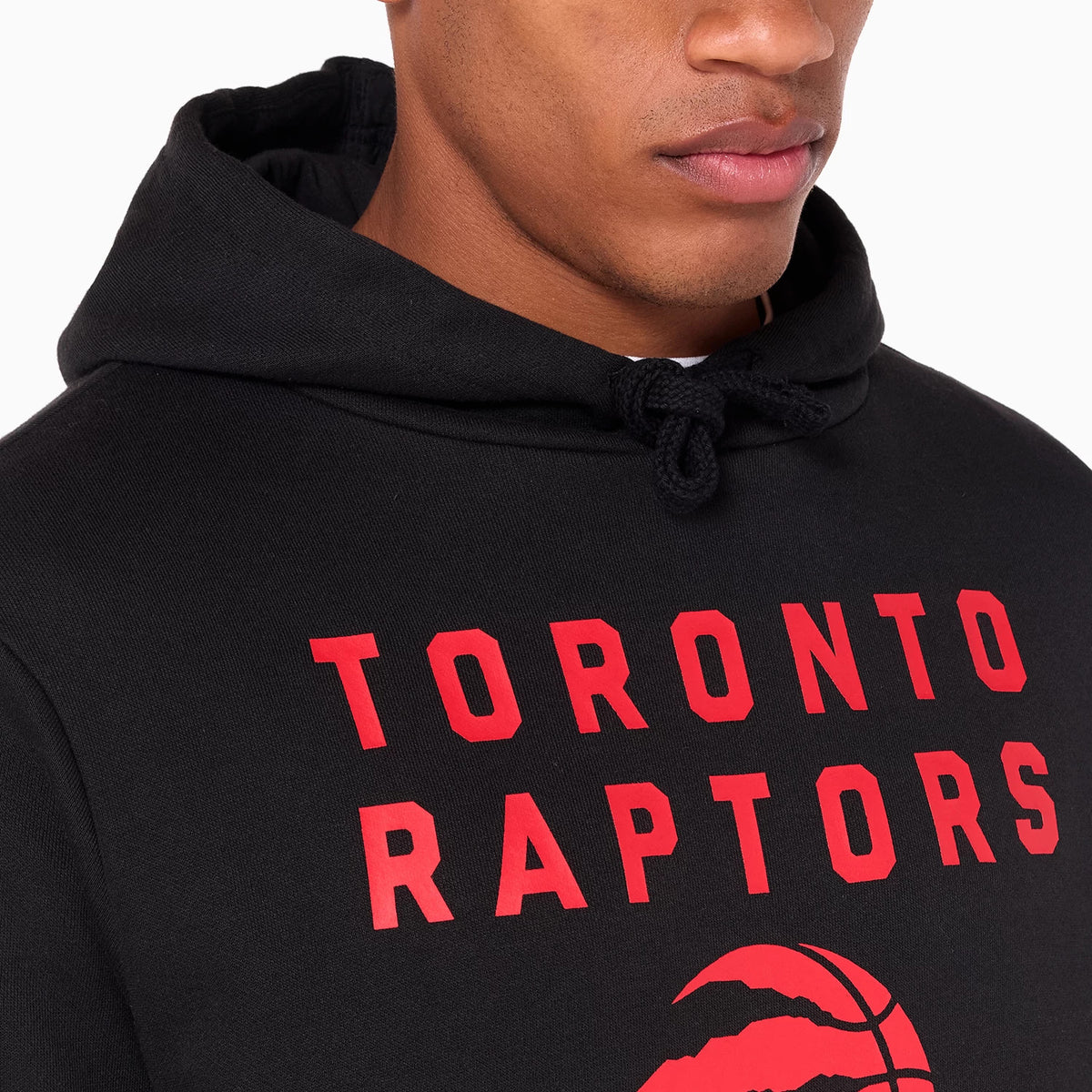 New Era Toronto Raptors NBA Black Pullover Hoodie, front view showing the bold red lettering across the chest with a basketball claw graphic below, a drawstring hood resting at the back.