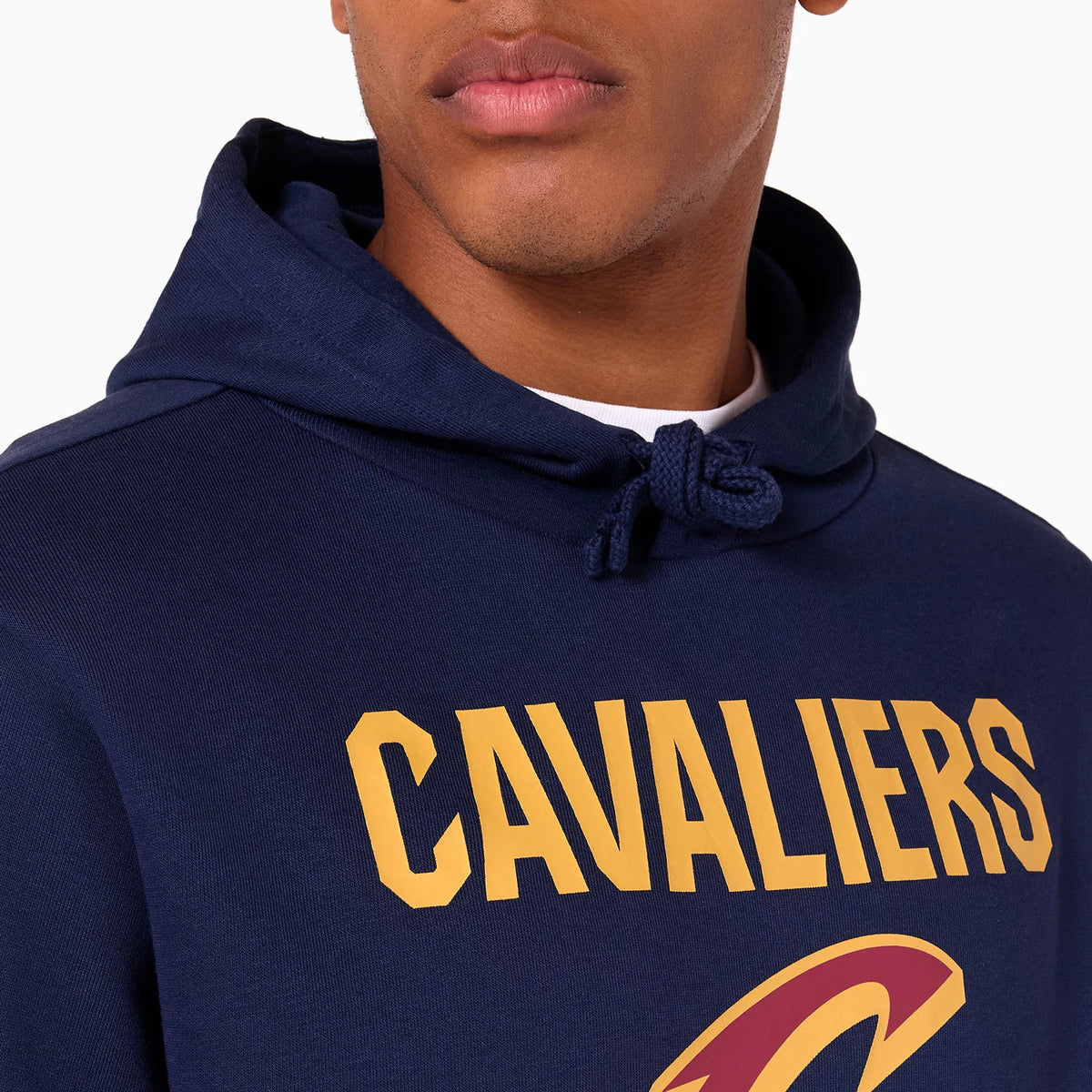 New Era Cleveland Cavaliers NBA Navy Pullover Hoodie, on-model view showing the upper part with a drawstring hood, yellow CAVALIERS text across the chest, and part of the Cavaliers logo below.