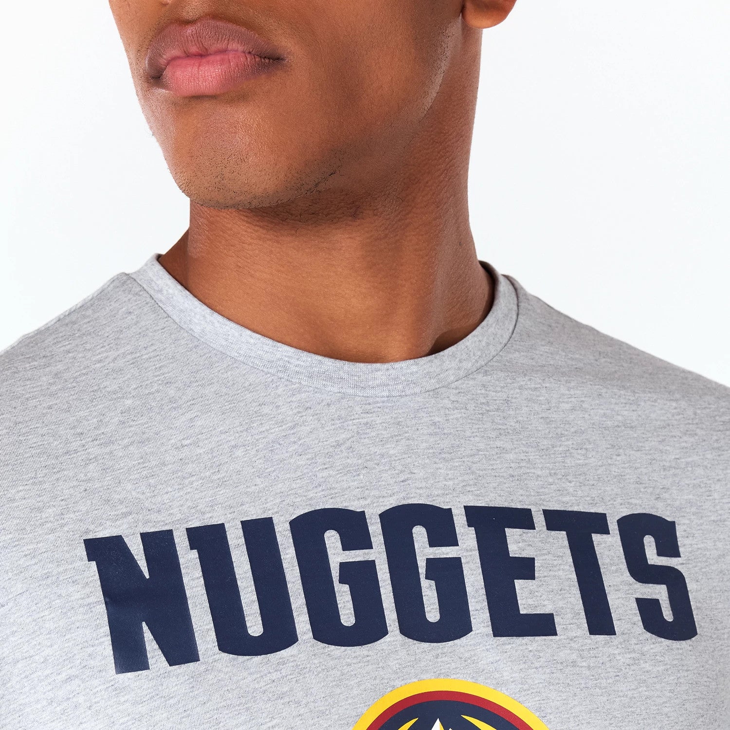 New Era Denver Nuggets NBA Grey T-Shirt, on-model view showing the light grey fabric with large navy lettering spelling NUGGETS across the chest, round neckline and part of the logo visible below.
