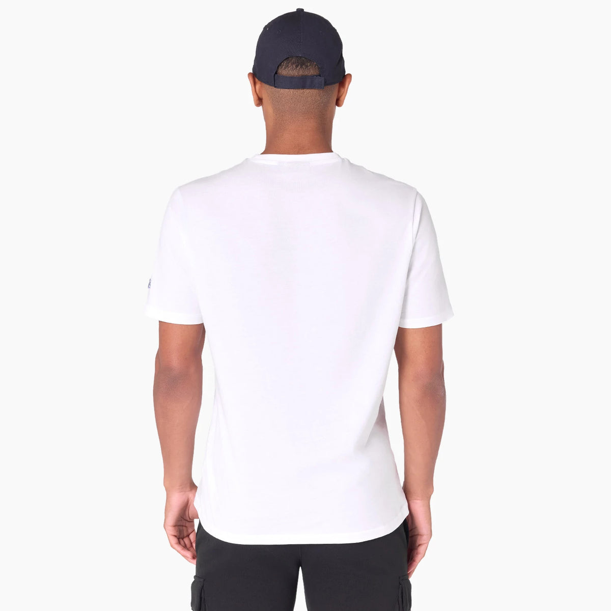New Era Minnesota Timberwolves NBA White T-Shirt, rear view showing the plain white fabric with short sleeves, worn by a model facing away and wearing a navy cap, displaying a simple and clean back design.