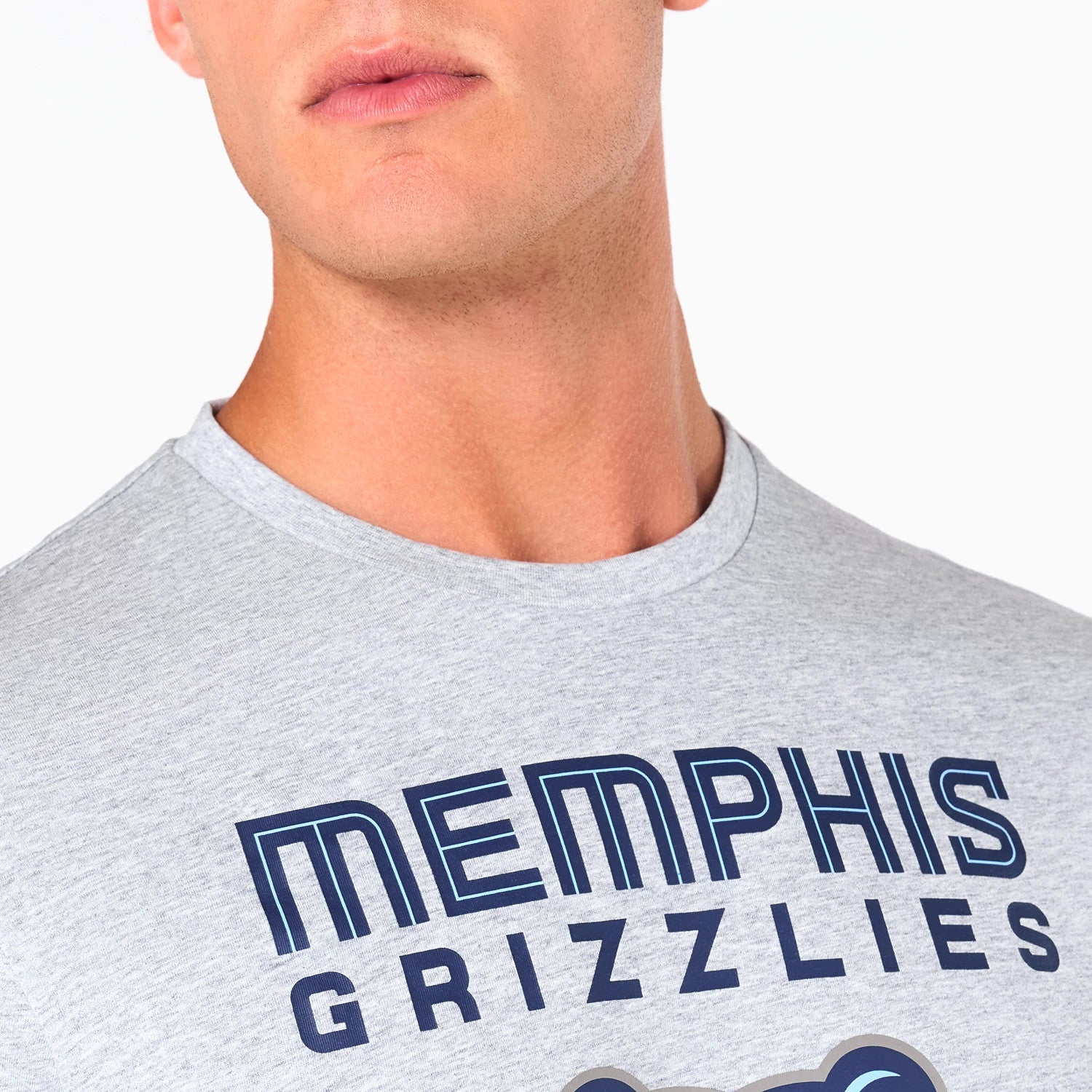 New Era Memphis Grizzlies NBA Grey T-Shirt, front view showing the close-up of the grey fabric with bold navy lettering spelling Memphis Grizzlies across the chest, partially visible graphic detail beneath the text.