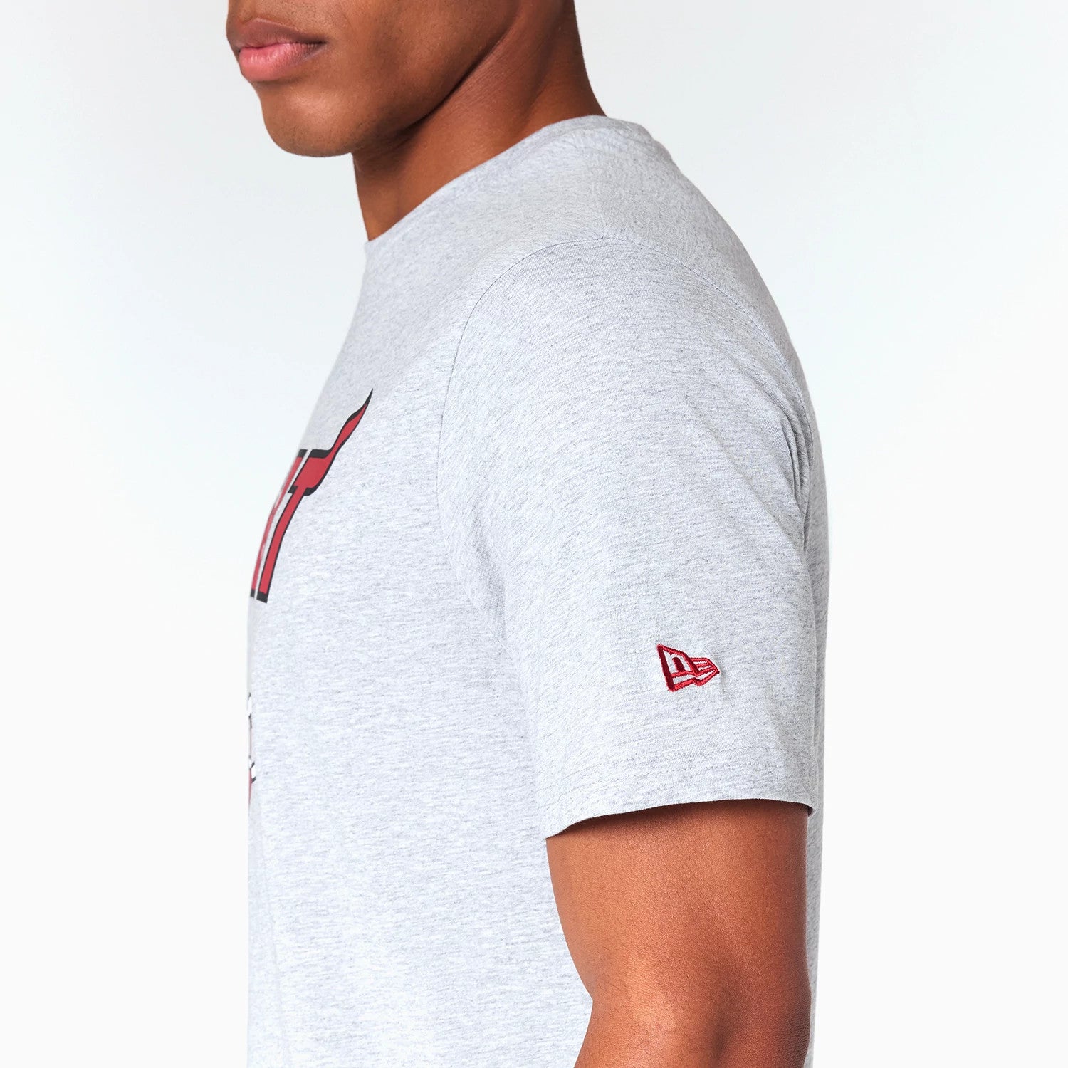 New Era Miami Heat NBA Grey T-Shirt, side view showing the light grey fabric with a red debossed New Era logo on the left sleeve and part of the Miami Heat graphic visible on the chest.