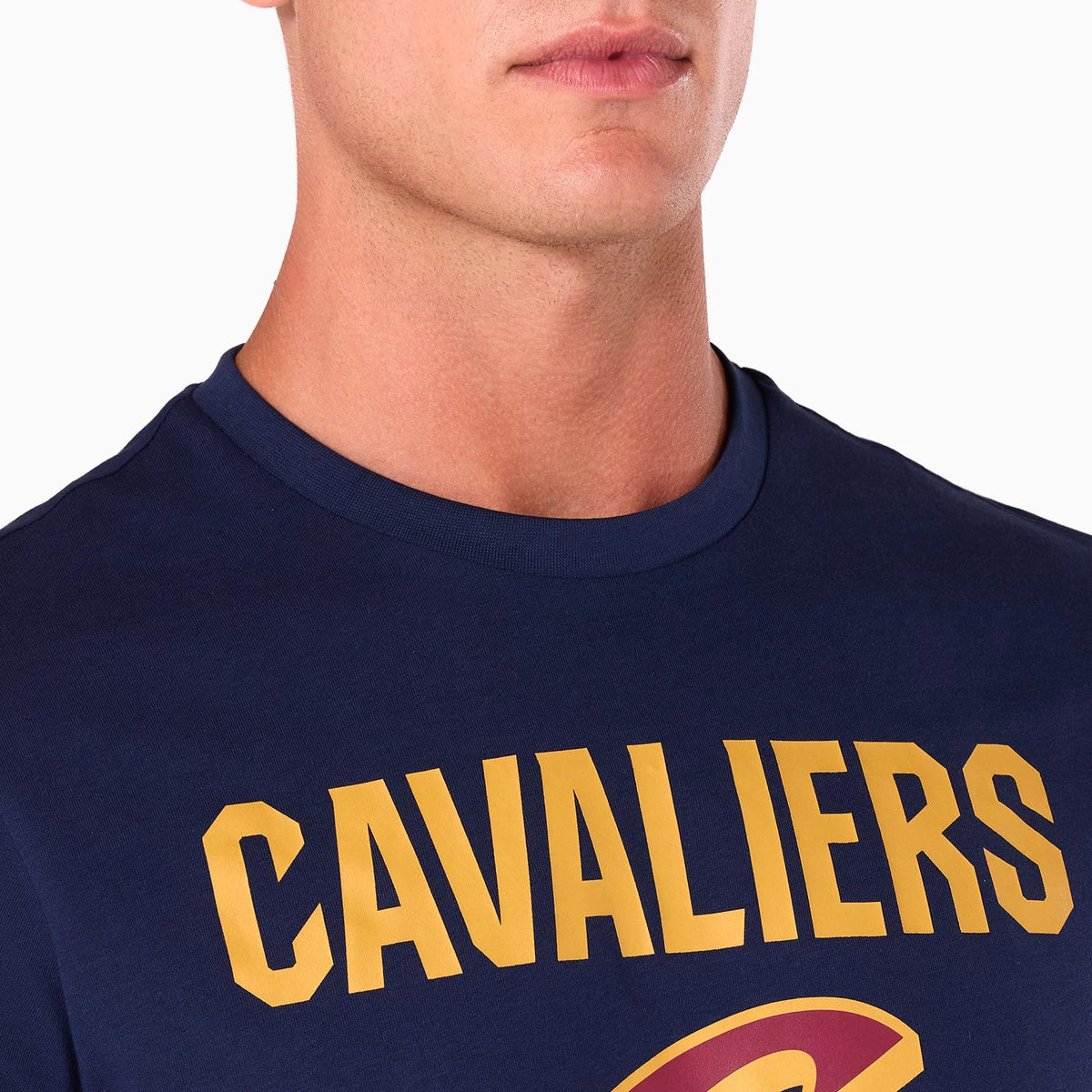 New Era Cleveland Cavaliers NBA Navy T-Shirt, on-model view showing the upper chest with large yellow CAVALIERS lettering across the front against the navy fabric, featuring partial red and yellow logo detailing below the text.