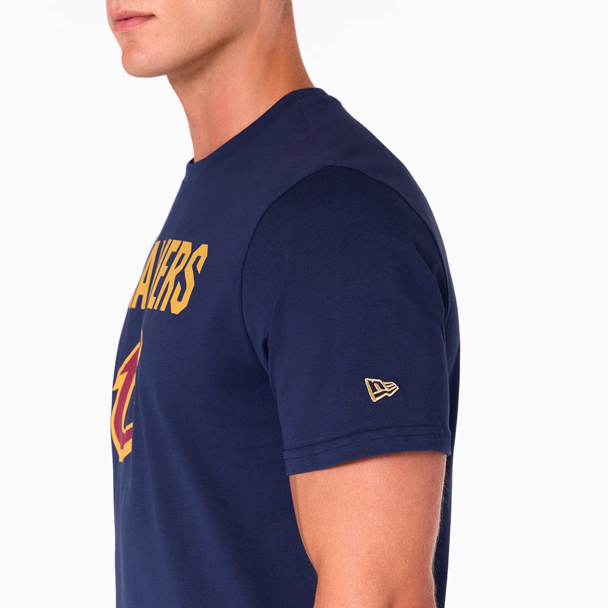 New Era Cleveland Cavaliers NBA Navy T-Shirt, side view showing the navy fabric with a yellow printed Cavaliers logo across the chest and a raised New Era logo on the left sleeve near the shoulder.