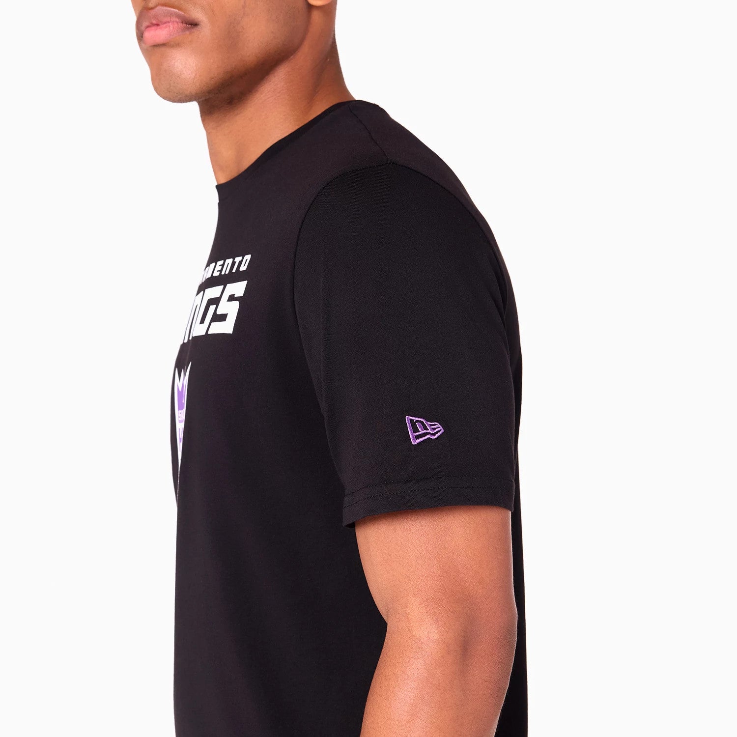 New Era Sacramento Kings NBA Black T-Shirt, side view showing a black short-sleeve design with a purple embroidered New Era logo on the left sleeve and part of the white Sacramento Kings text and logo on the chest.