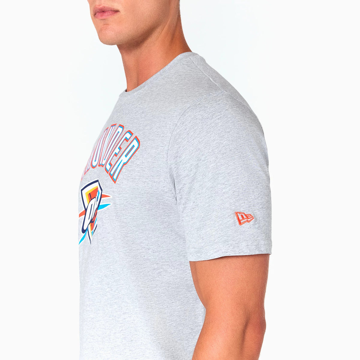 New Era Oklahoma City Thunder NBA Grey T-Shirt, side view showing the grey fabric with colourful team logo on the chest, red embroidered New Era logo on the sleeve, and a round neckline.