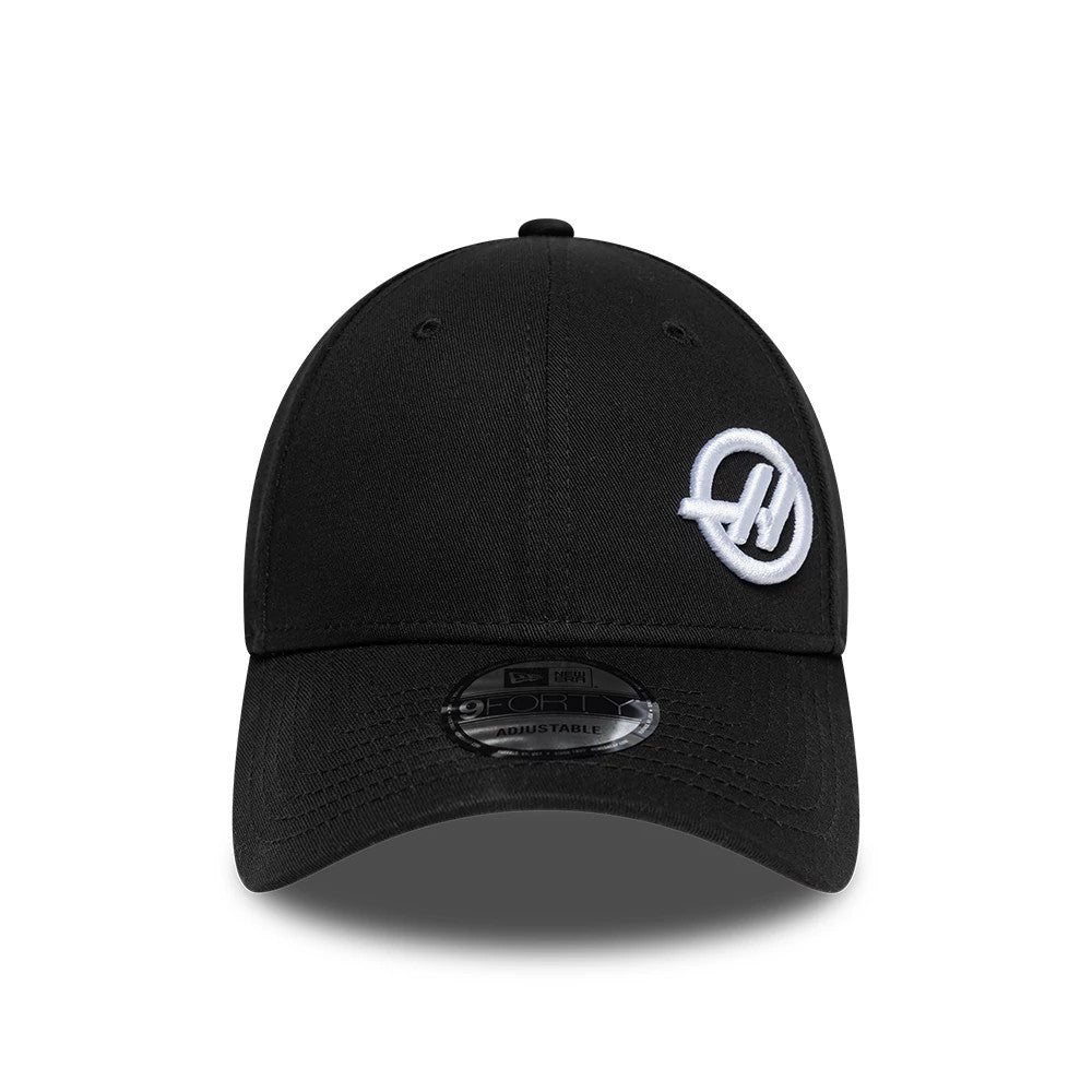 TGR Haas F1 Team Flawless Black New Era 9FORTY Adjustable Cap, front view with a white embroidered Haas logo on the black curved visor and a 9FORTY size sticker centred on the visor.