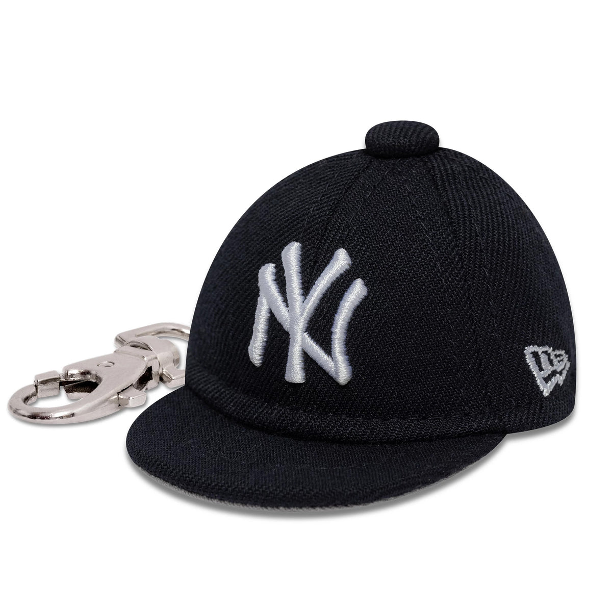 New Era New York Yankees MLB Mini Cap Navy Key Chain, side view showing the white embroidered NY logo on the front panel and the New Era flag logo on the left side, connected to a silver keychain hook.